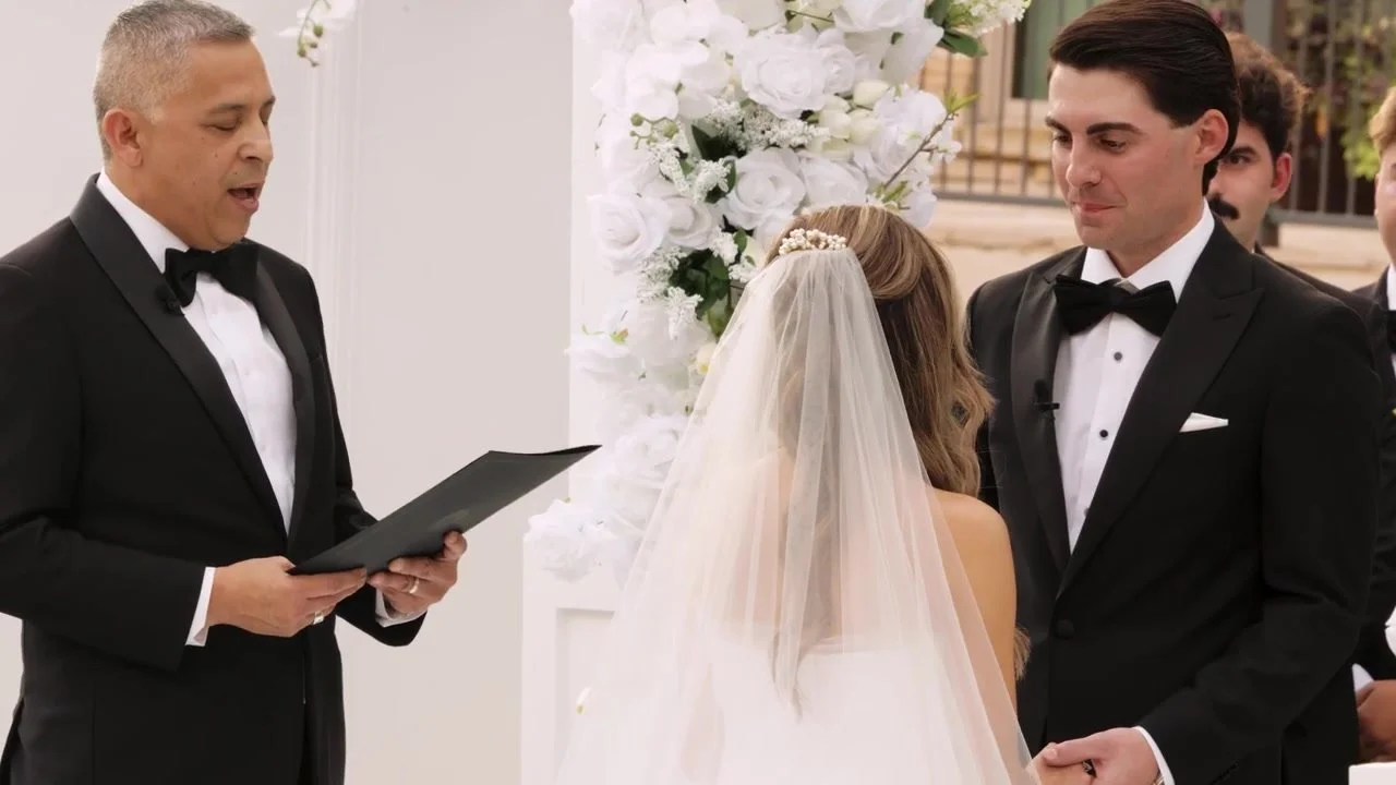 Corey and Emily holding hands with their officiant during vows at Red Berry Estate