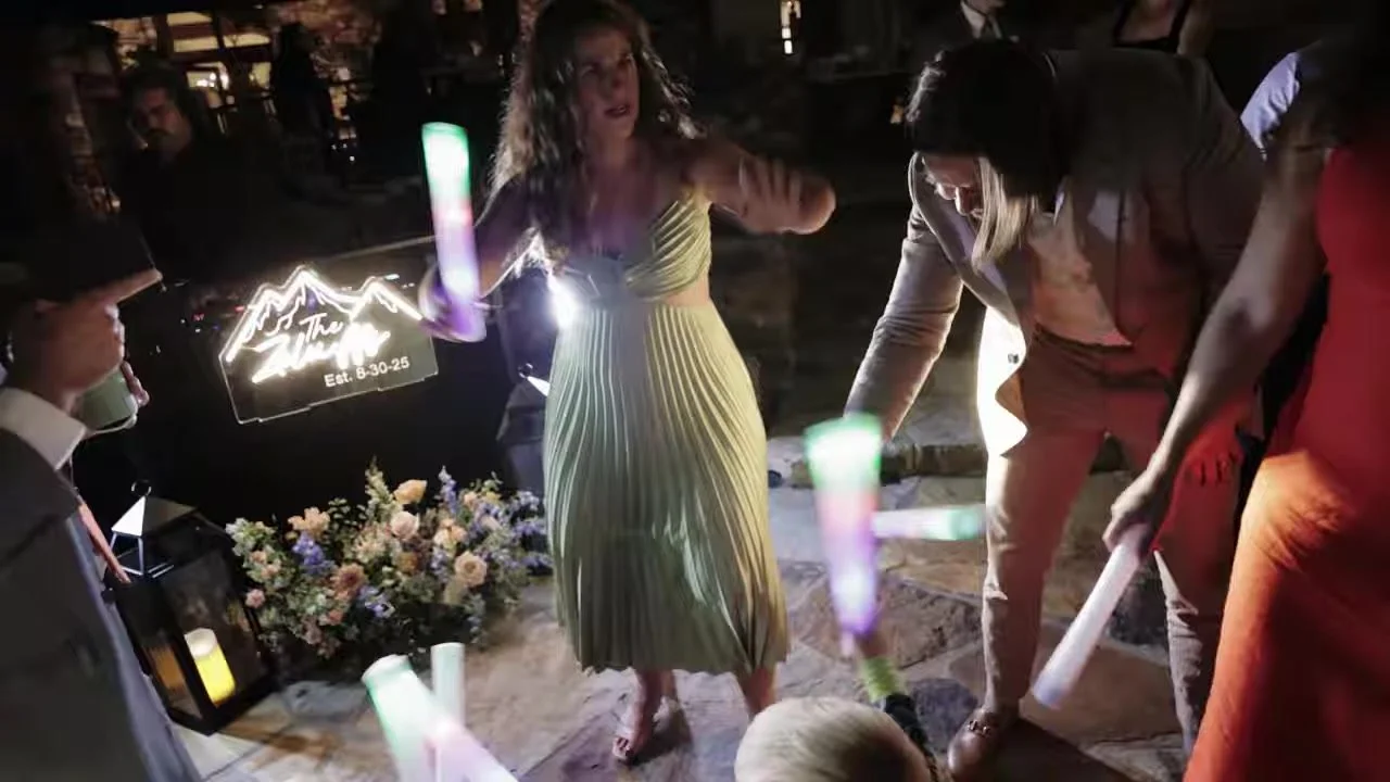 Dance floor with glow sticks and a mountain neon sign at Gold Mountain