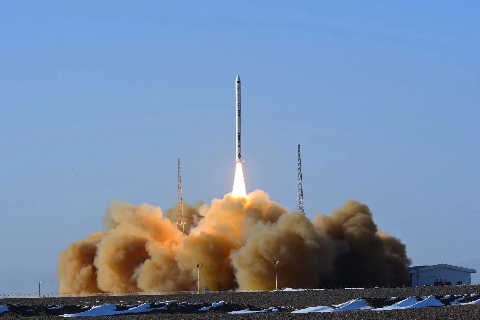 Hyperbola-1  launching into the sky with bright flames and smoke at the base during daytime.