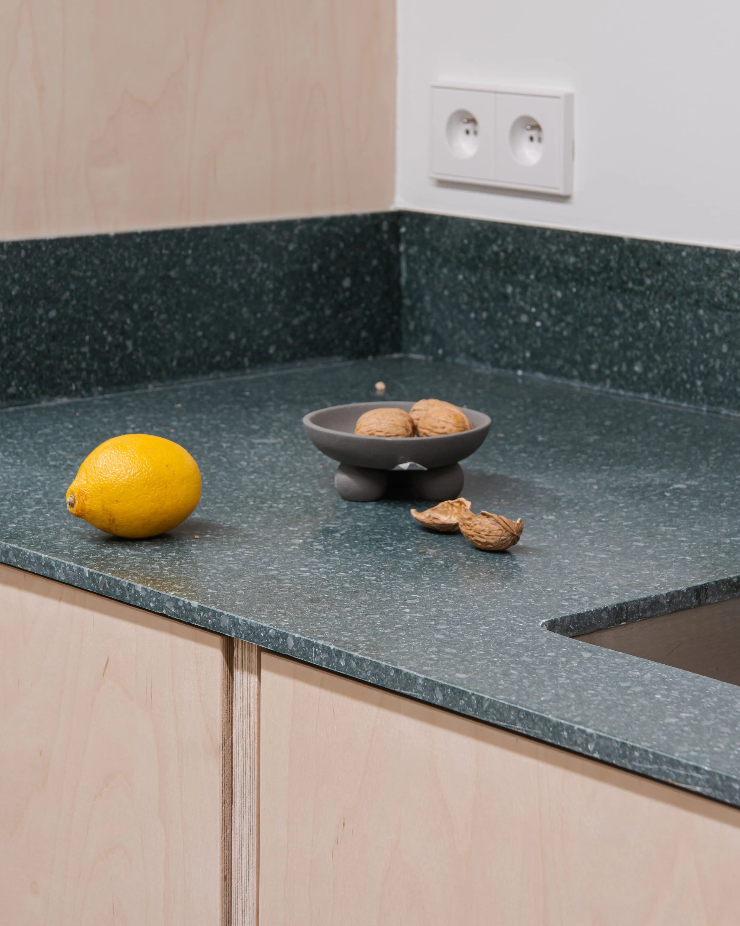 Countertop with a lemon and a bowl of walnuts