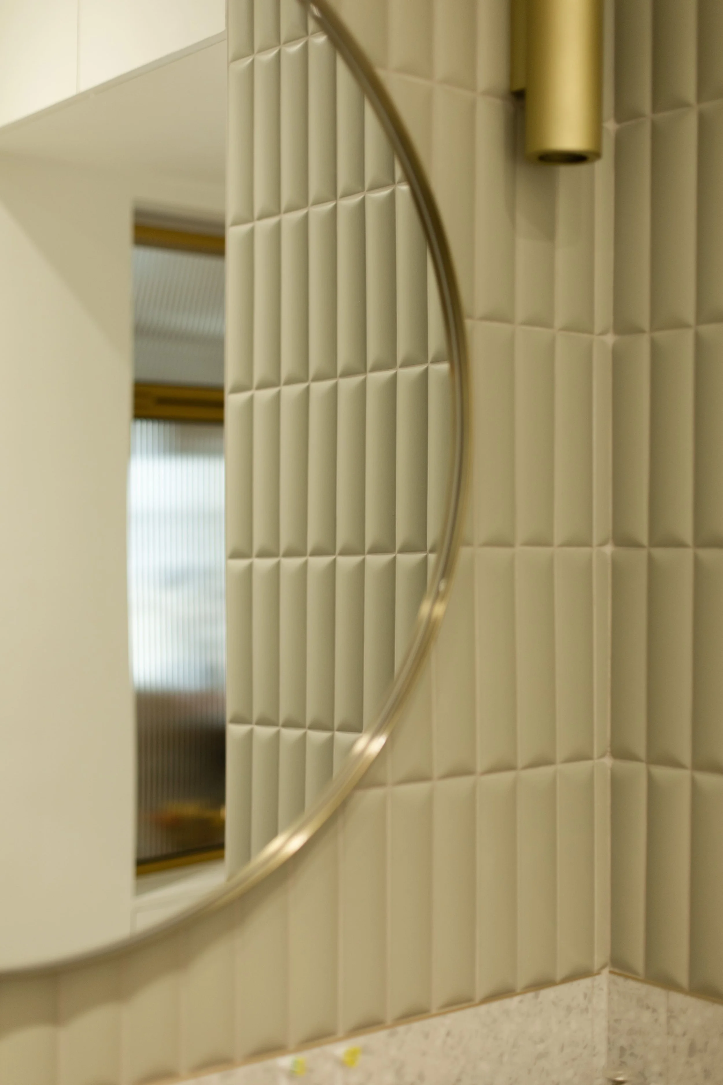 Miroir rond au mur avec carrelage en relief beige