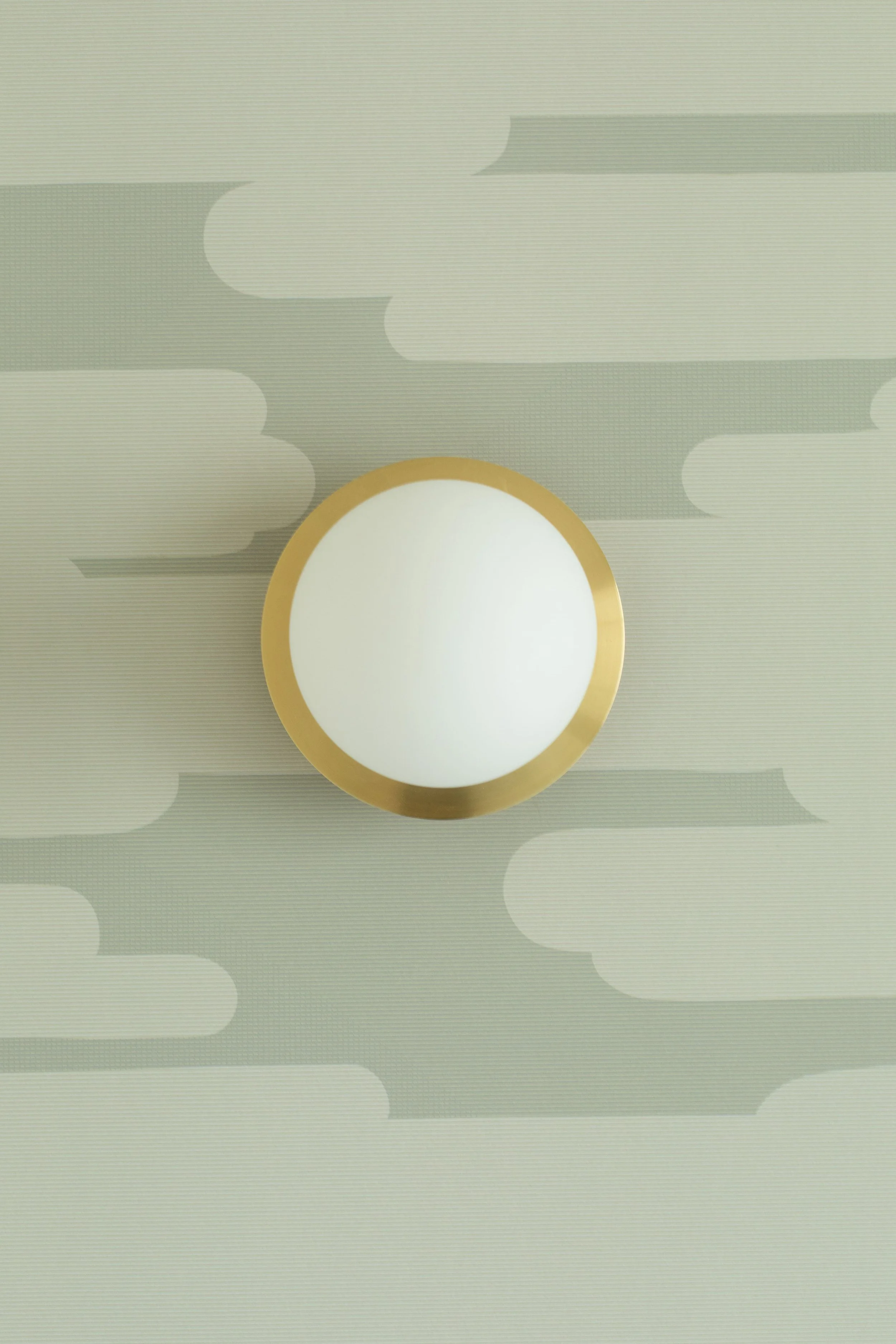 Lampe de plafond ronde blanche avec bord en or, fixée au plafond à motif nuages gris et blancs.