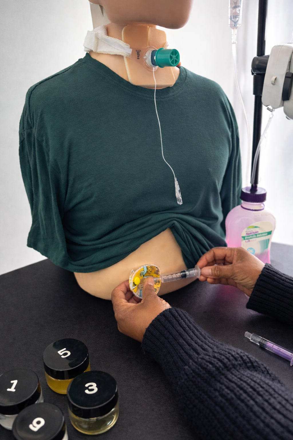 Learner changing the balloon water of a button device on a sim manikin