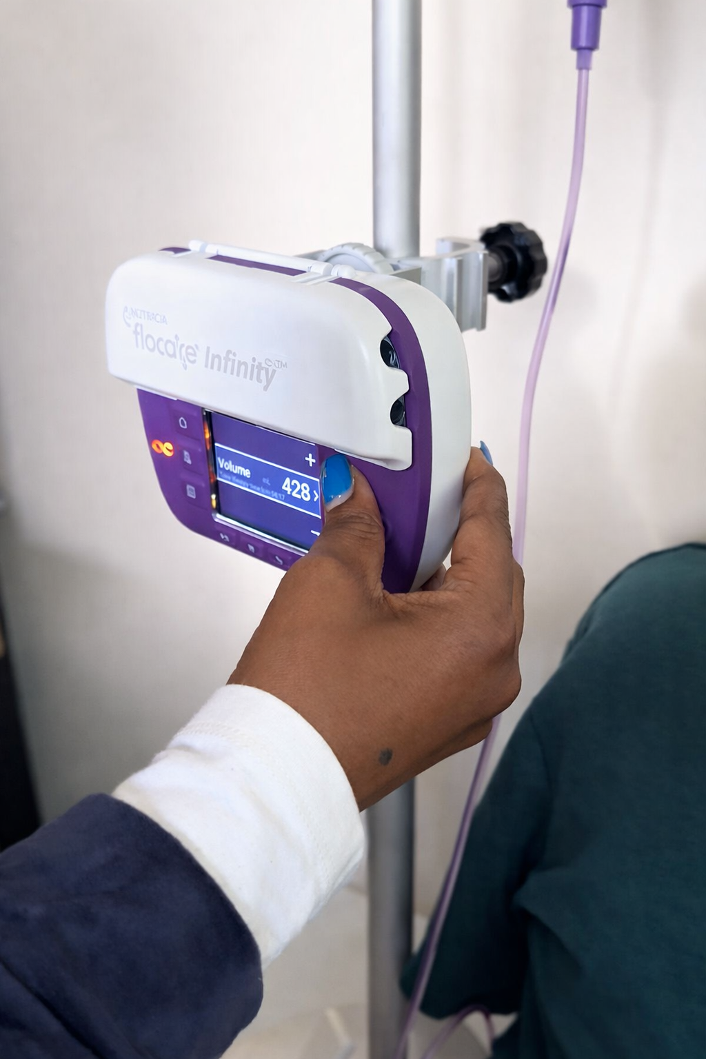 Learner adjusting enteral feeding nutricia pump during PEG feeding training workshop.