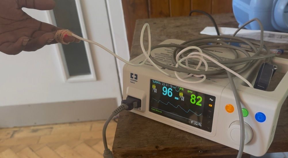 An oxygen saturation monitor on a learners finger showing 96% and HR 82