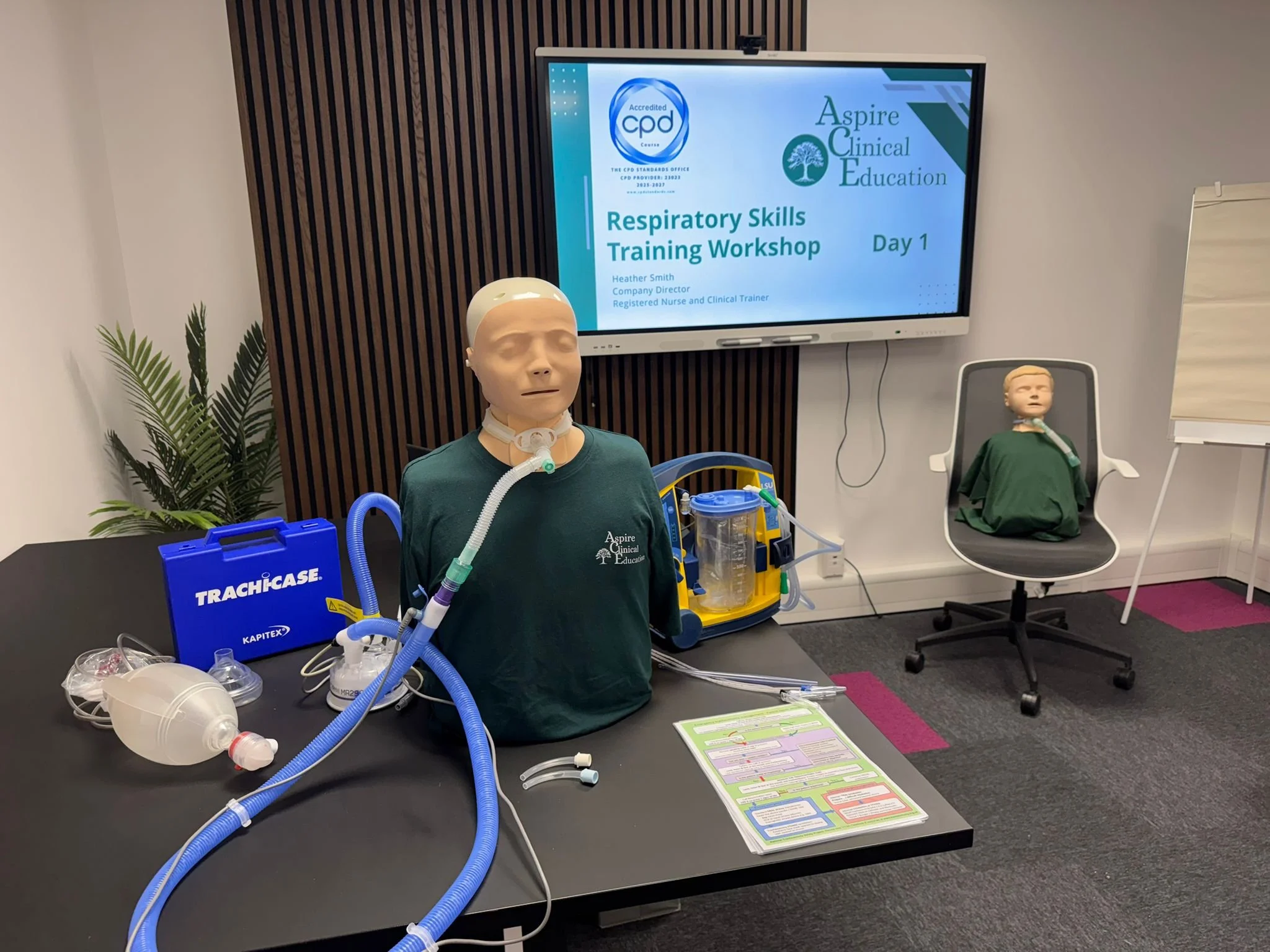Respiratory Training Workshop image with simulation manikin with tracheostomy, suction machine and emergency equipment