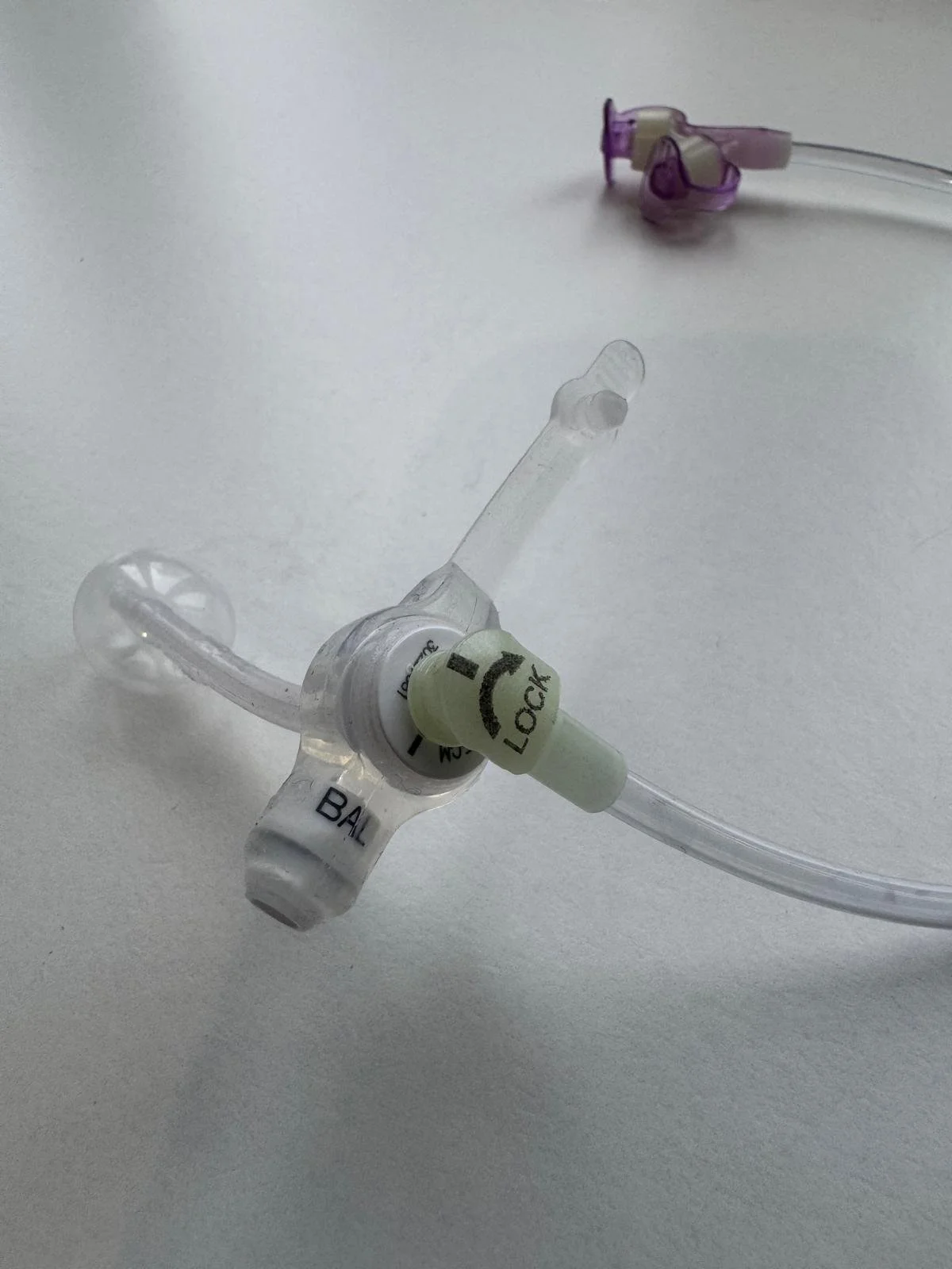 A close up of a low profile button device with an extension set attached