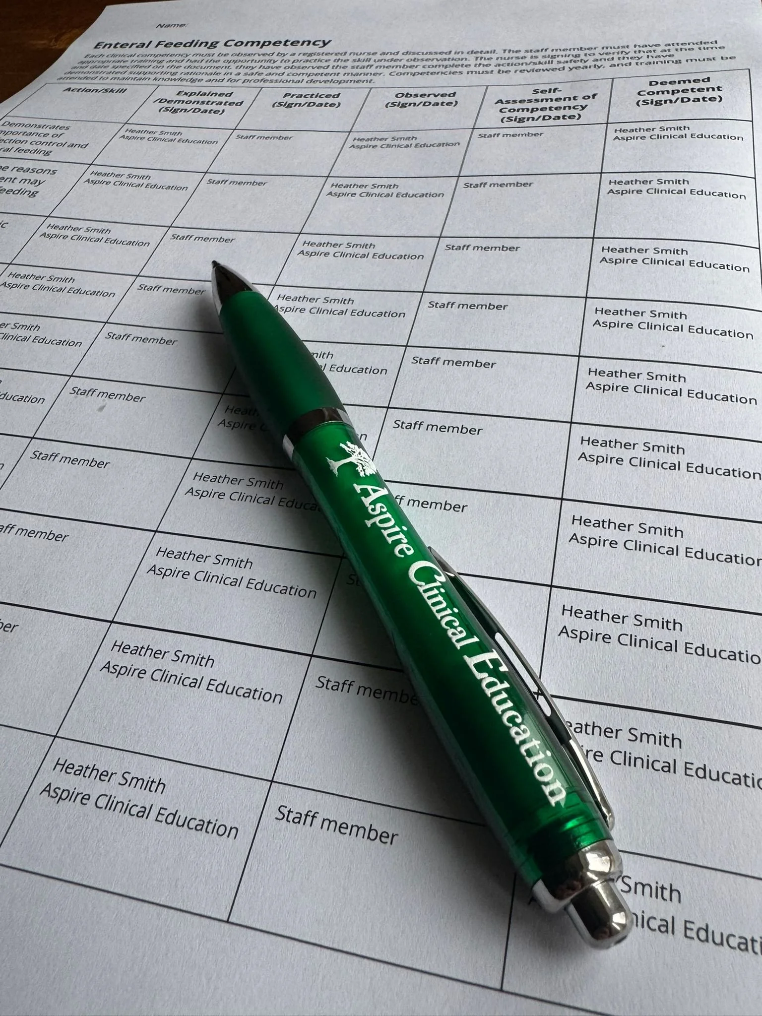An Aspire Clinical Education pen ontop of a competency document close up