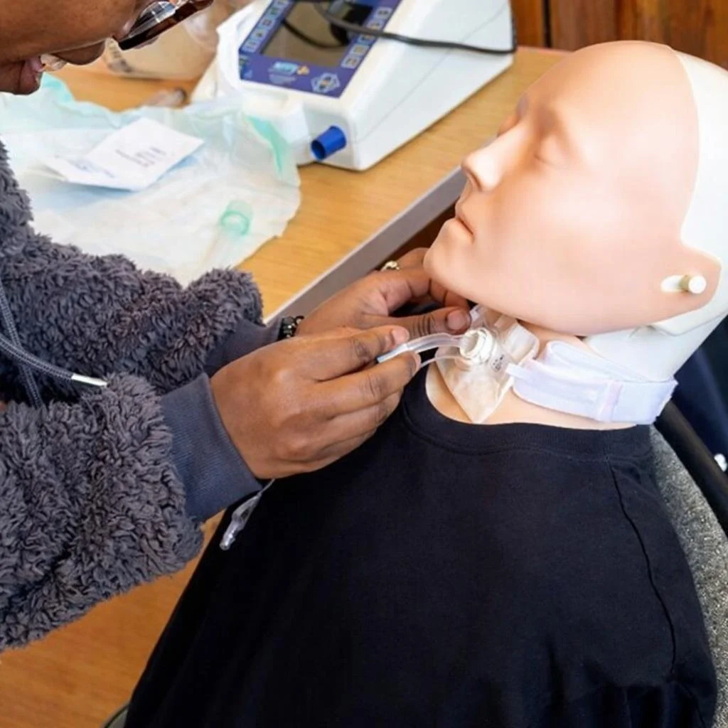 learner securing the tracheostomy tube whilst changing the inner cannula