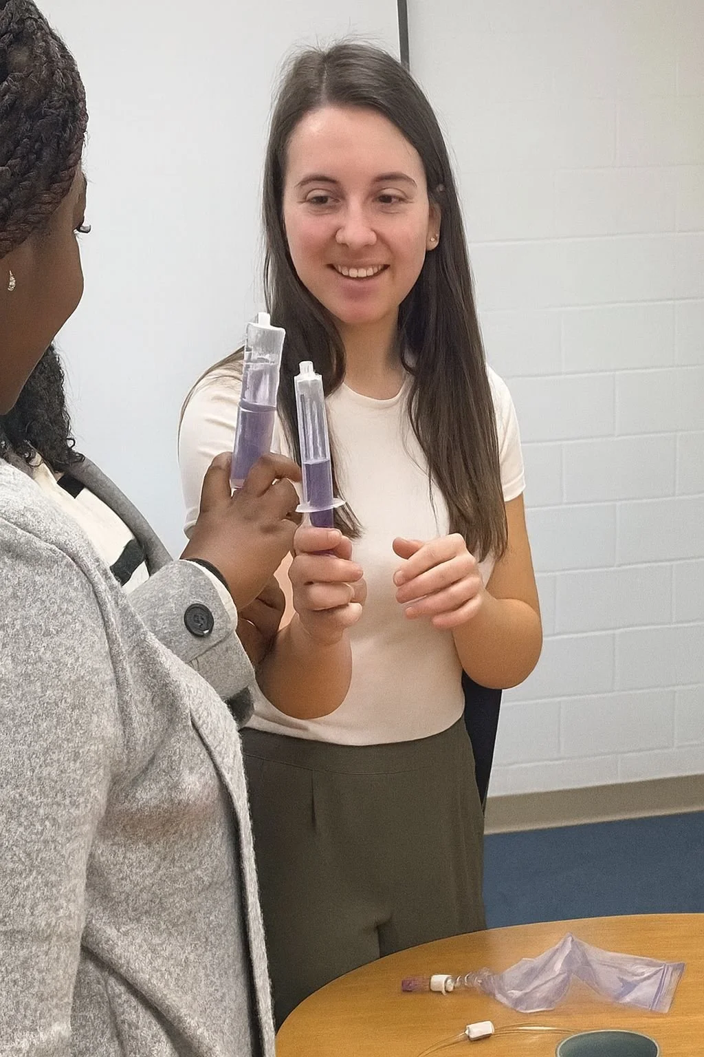 Heather demonstrating with PEG syringes and another learner