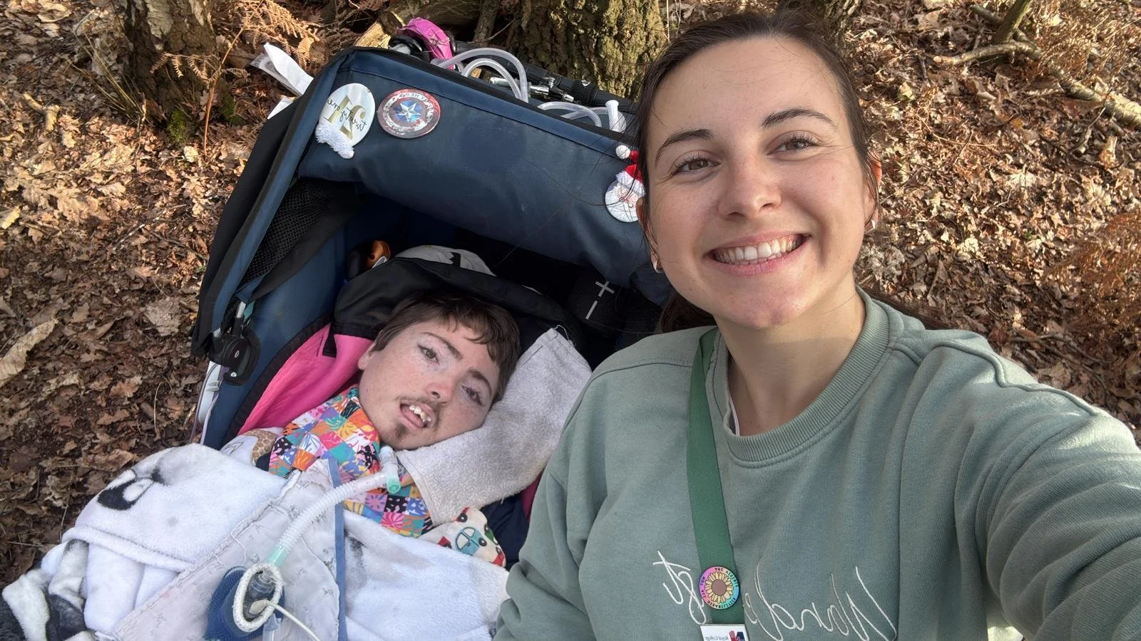 Heather taking a selfie with client in wheelchair in the sun