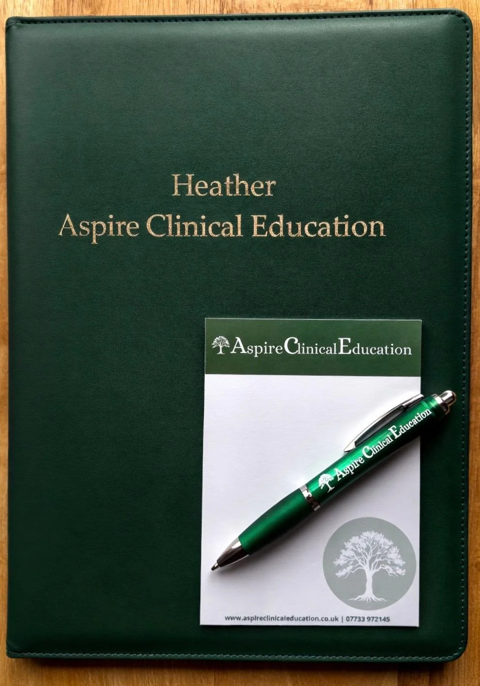 Green Aspire folder with notepad and pen