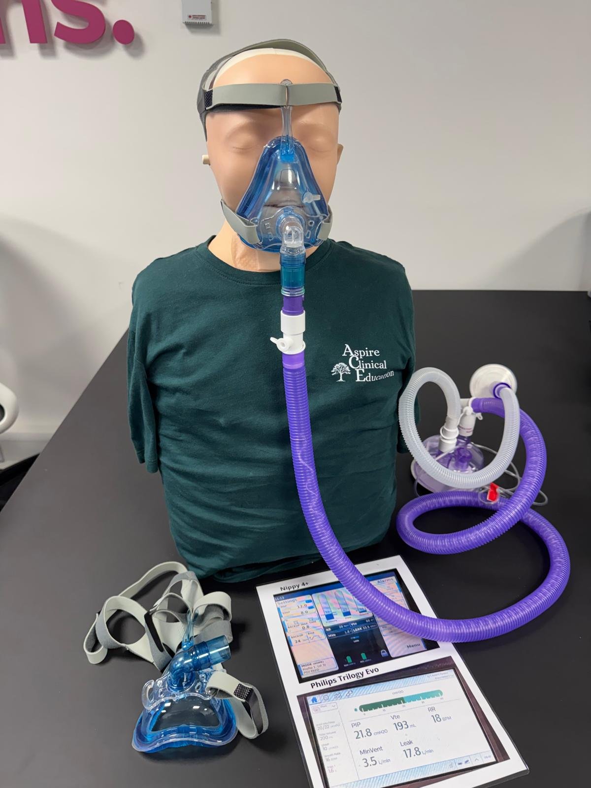 Sim manikin wearing NIV mask with information sheet and spare masks