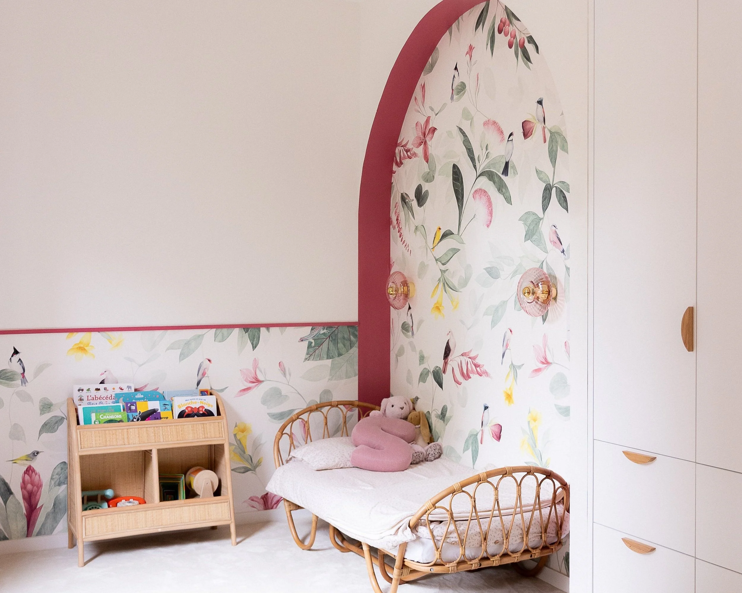 Chambre de petite fille entièrement rénovée avec un papier peint floral et des touches de rose