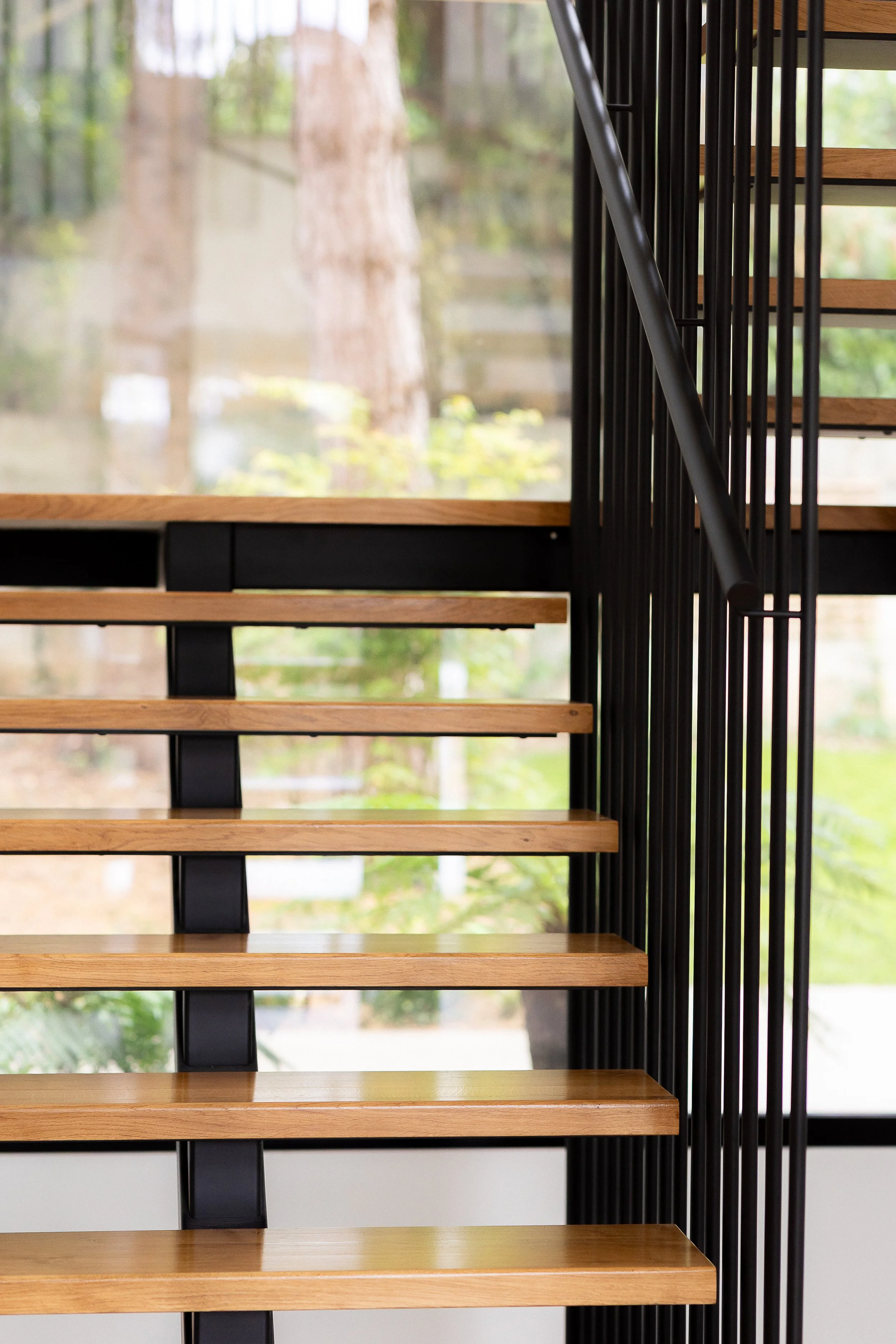 Escalier en métal et bois sans contre marche, laissant passer toute la lumière de l'extérieur