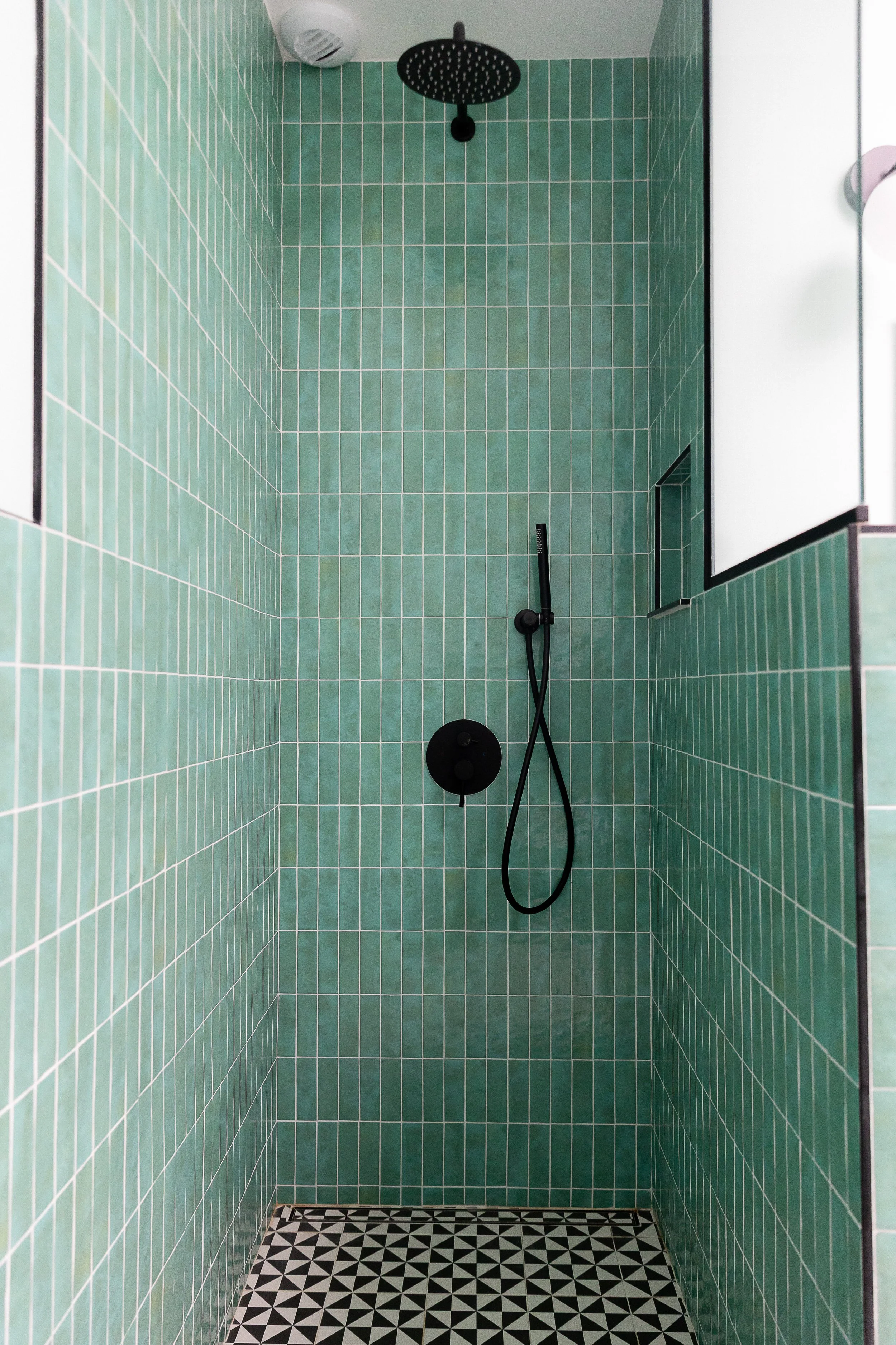 Douche rénovée en carrelage vert associé et des finitions noires mates