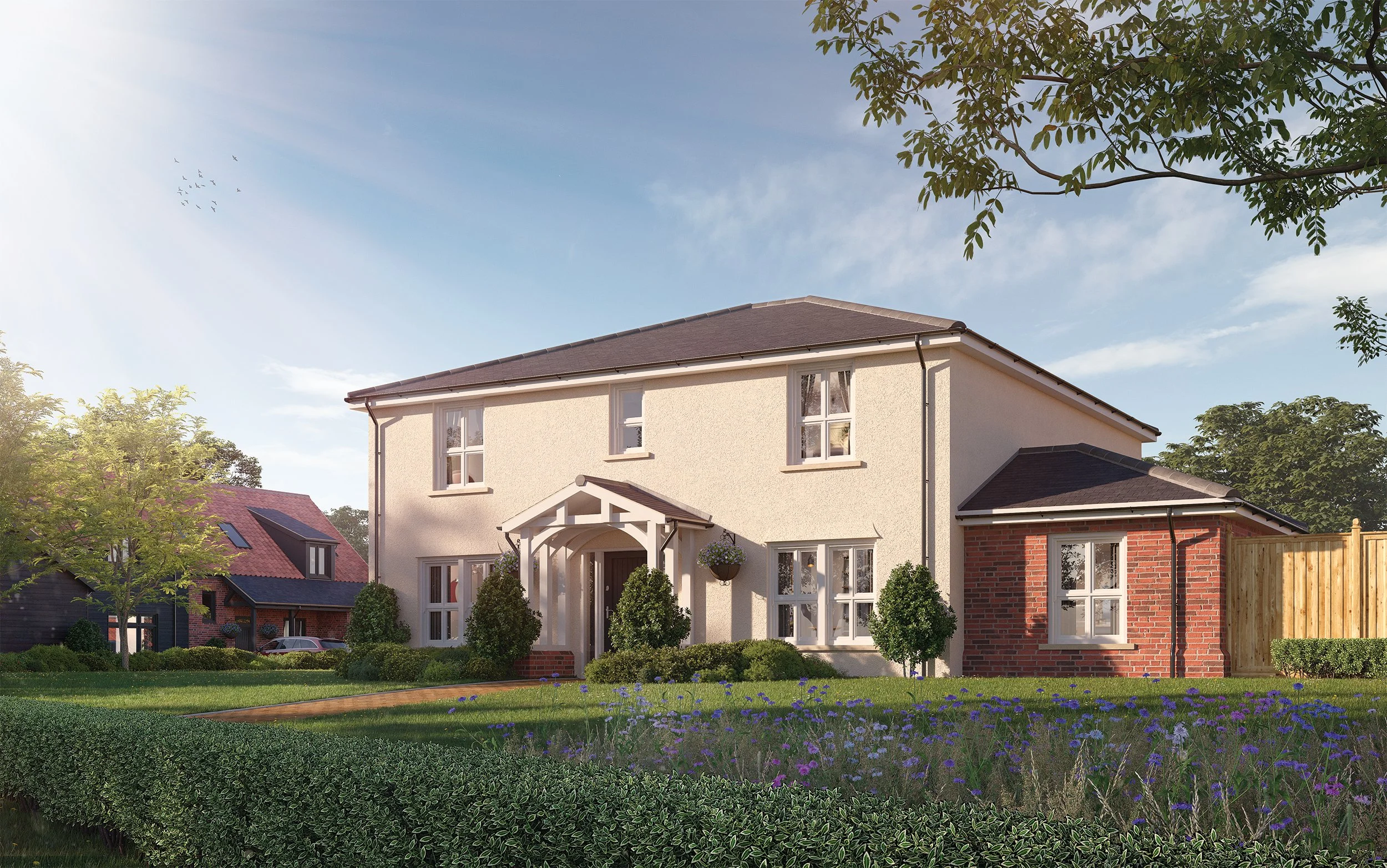 A modern two-story house with a white exterior and brick accents, surrounded by a well-manicured garden with green shrubs, flowering plants, and trees, under a clear blue sky with sunlight.