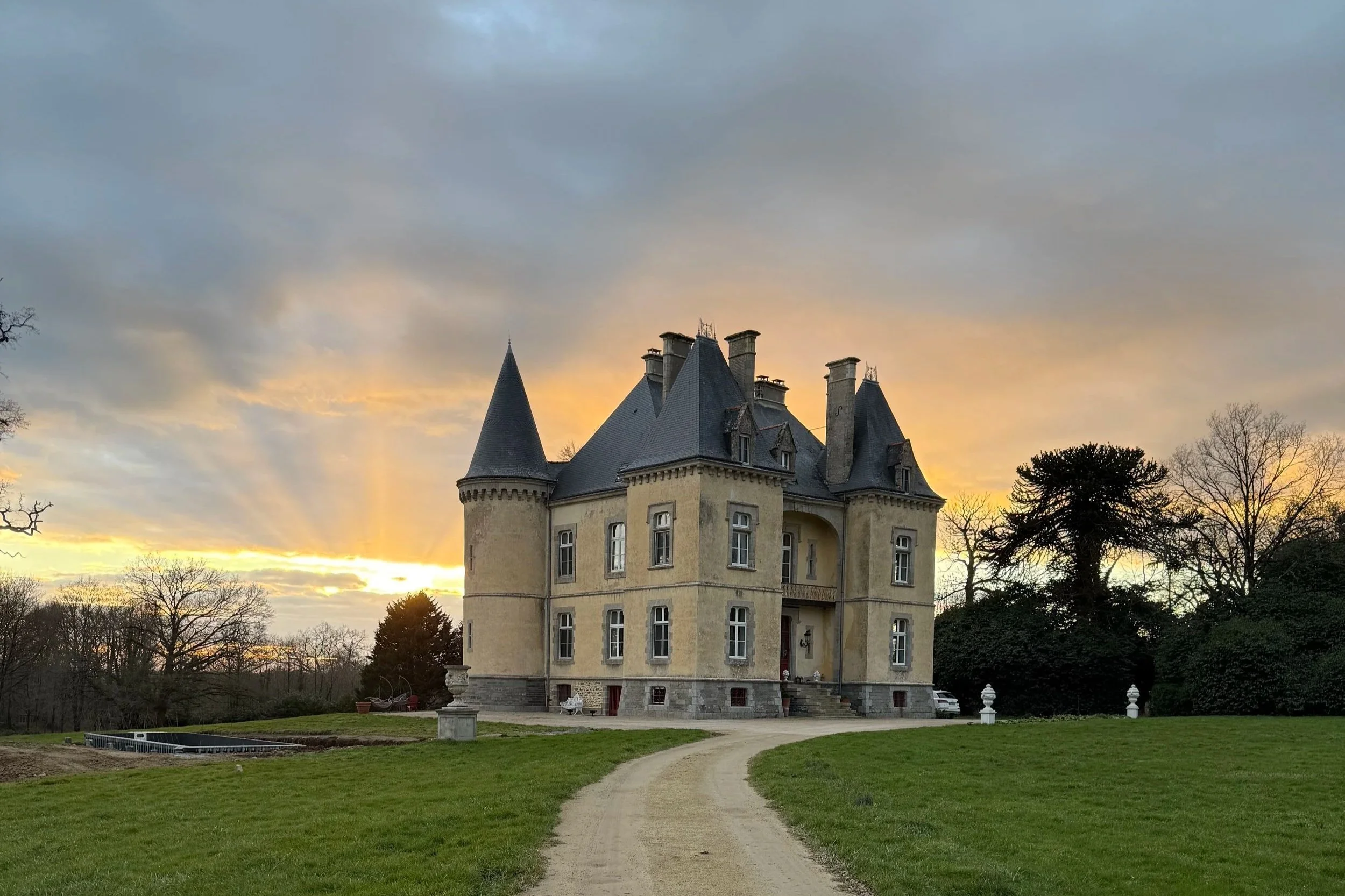 Image of Coin de Paix at Chateau de Launay in Saint Vincent Sur Oust France a chateau built in 1865 with 4 towers and a 6 hectare parc surrounded by trees and grass meadows. Cream color chateau with a black slate roof