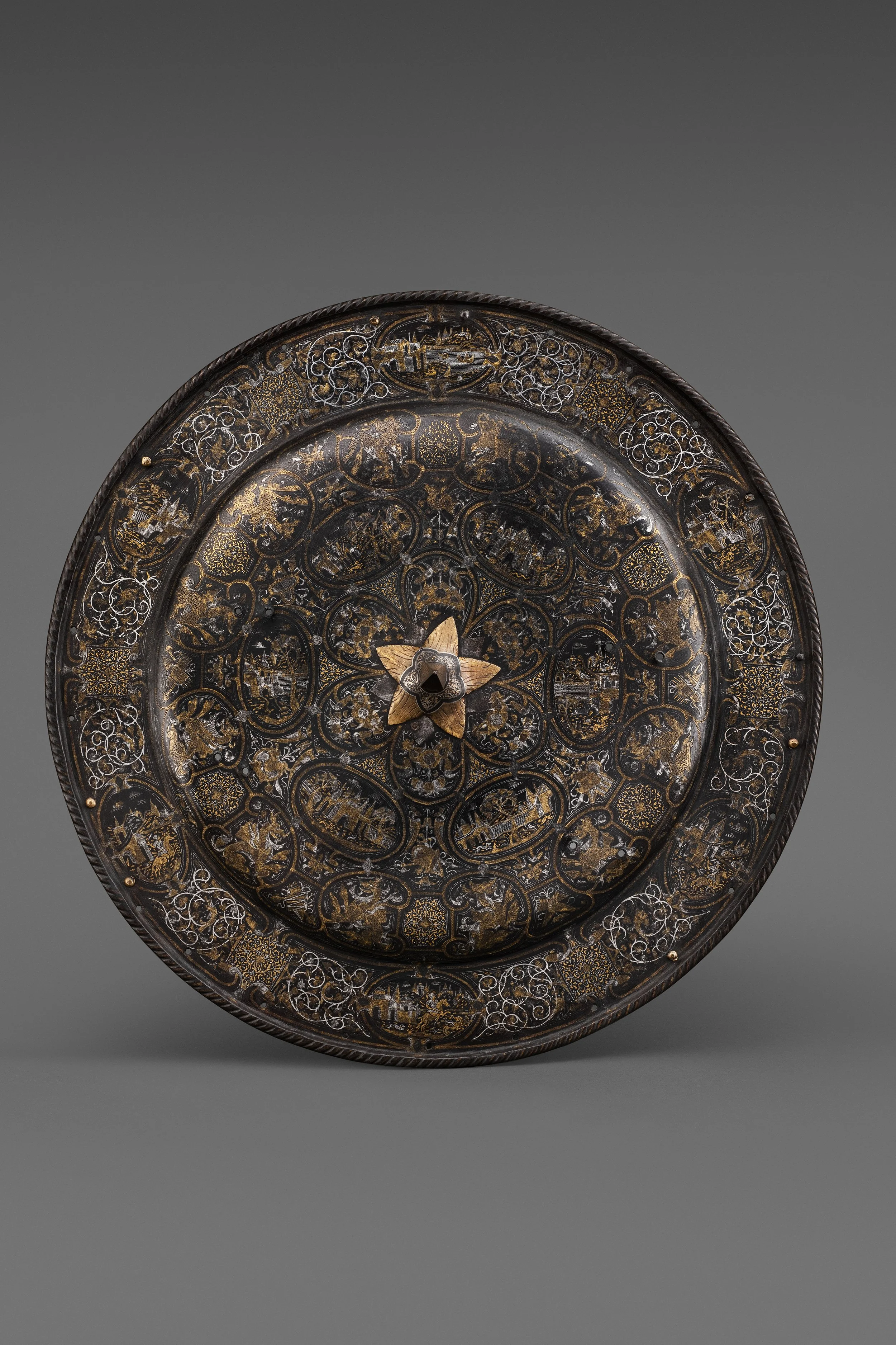  An Extremely Rare Milanese Parade Shield Damascened in Gold and Silver , c. 1565–75 
steel, gold, silver, copper alloy 
diameter: 58 cm (22.8 in.)