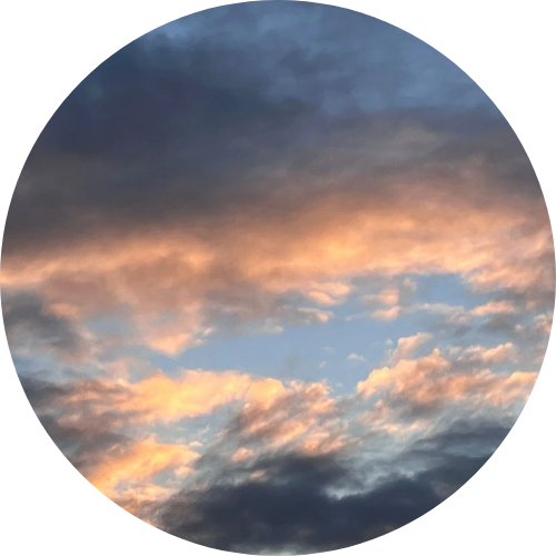 De Bron code stoel bedekt met bont, geplaatst op de oever van een meer met de zon die weerkaatst op het water, en een eiland of landmassa op de achtergrond tegen een blauwe hemel.