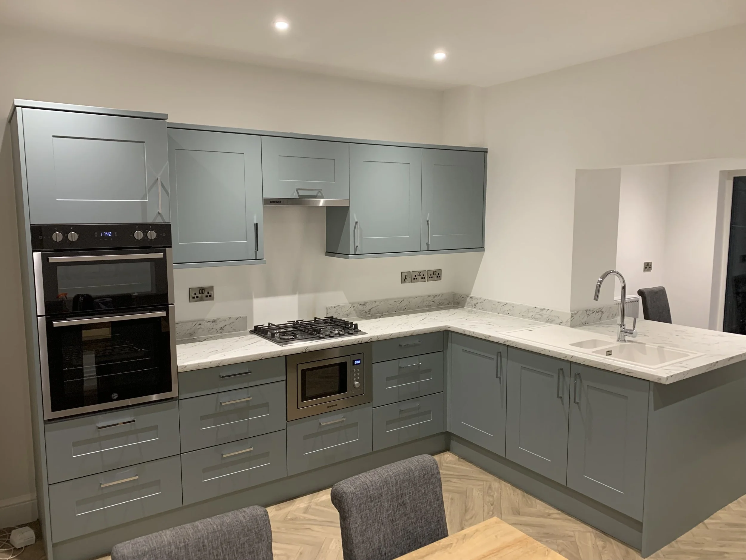 L Shaped Kitchen with Shaker Style Door, T-Bar Handles, Marble Look Worktop