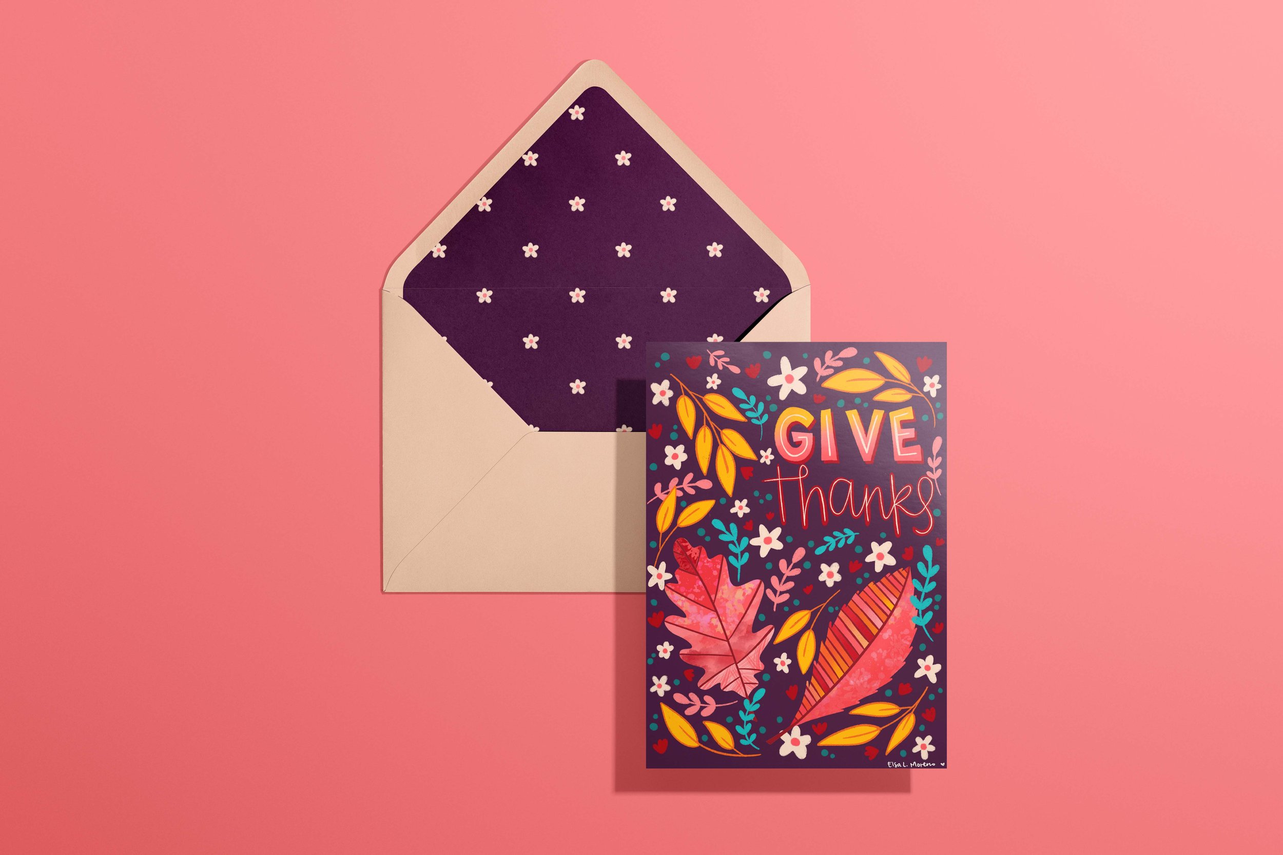 A card and envelope featuring leaves, branches and flowers in autumnal colors and the hand lettered message "Give Thanks". The envelope features a coordinating floral pattern inside.