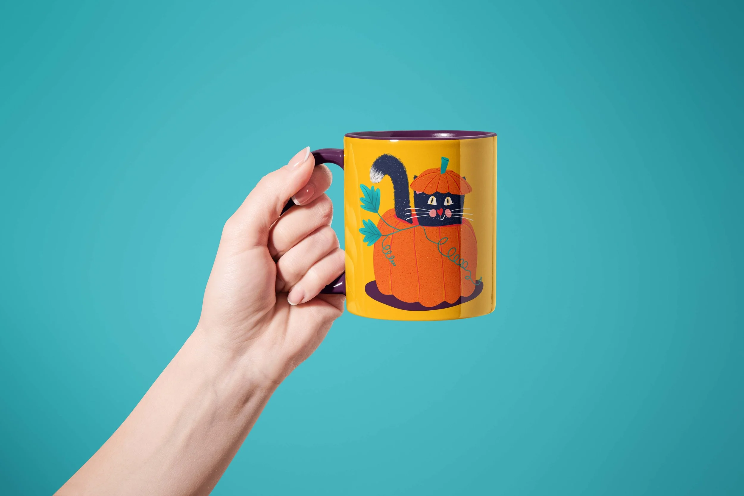 A hand holding a yellow Halloween mug depicting a black cat inside a pumpkin, all over a turquoise background