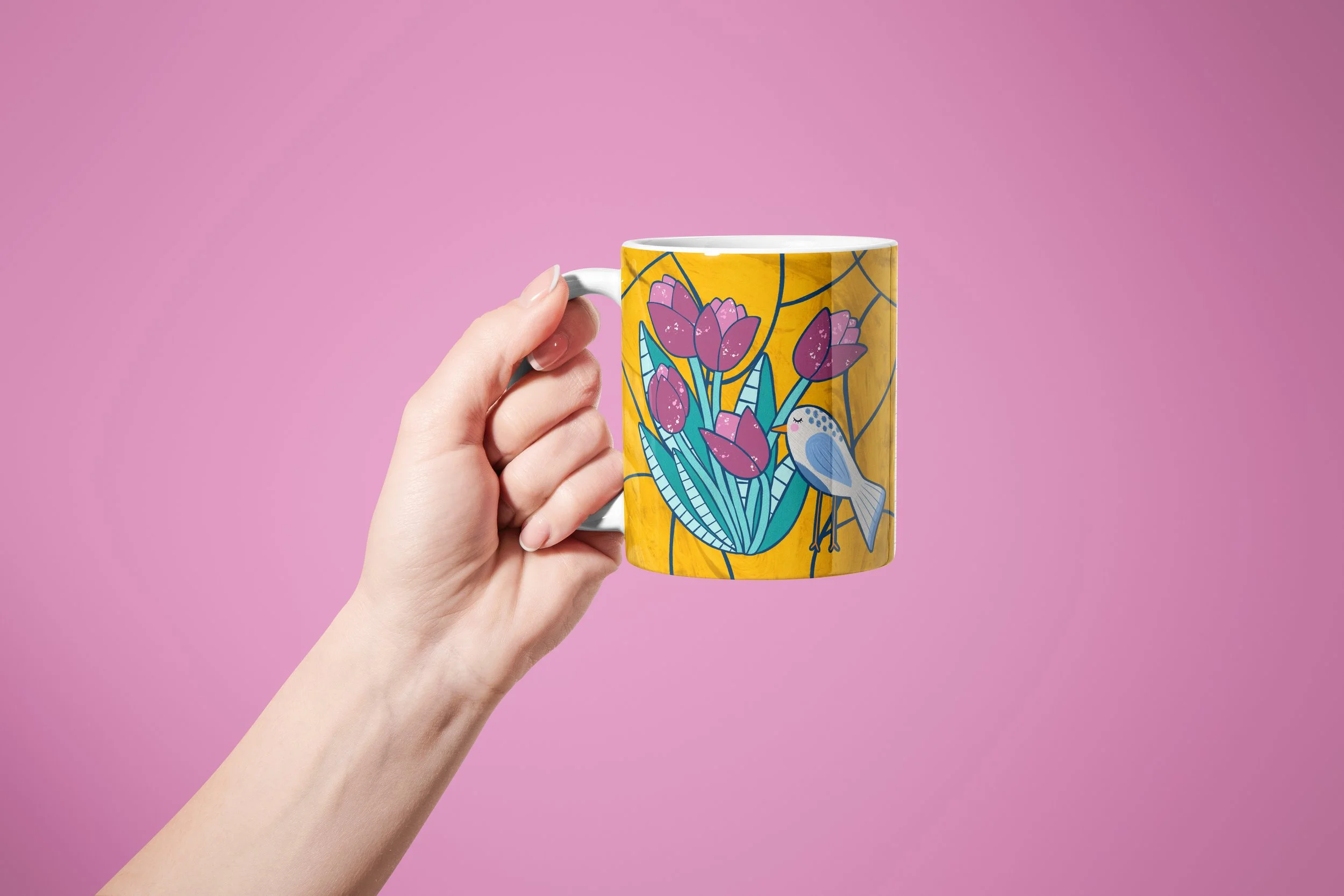 Hand holding a mug with a tulips and bird motif