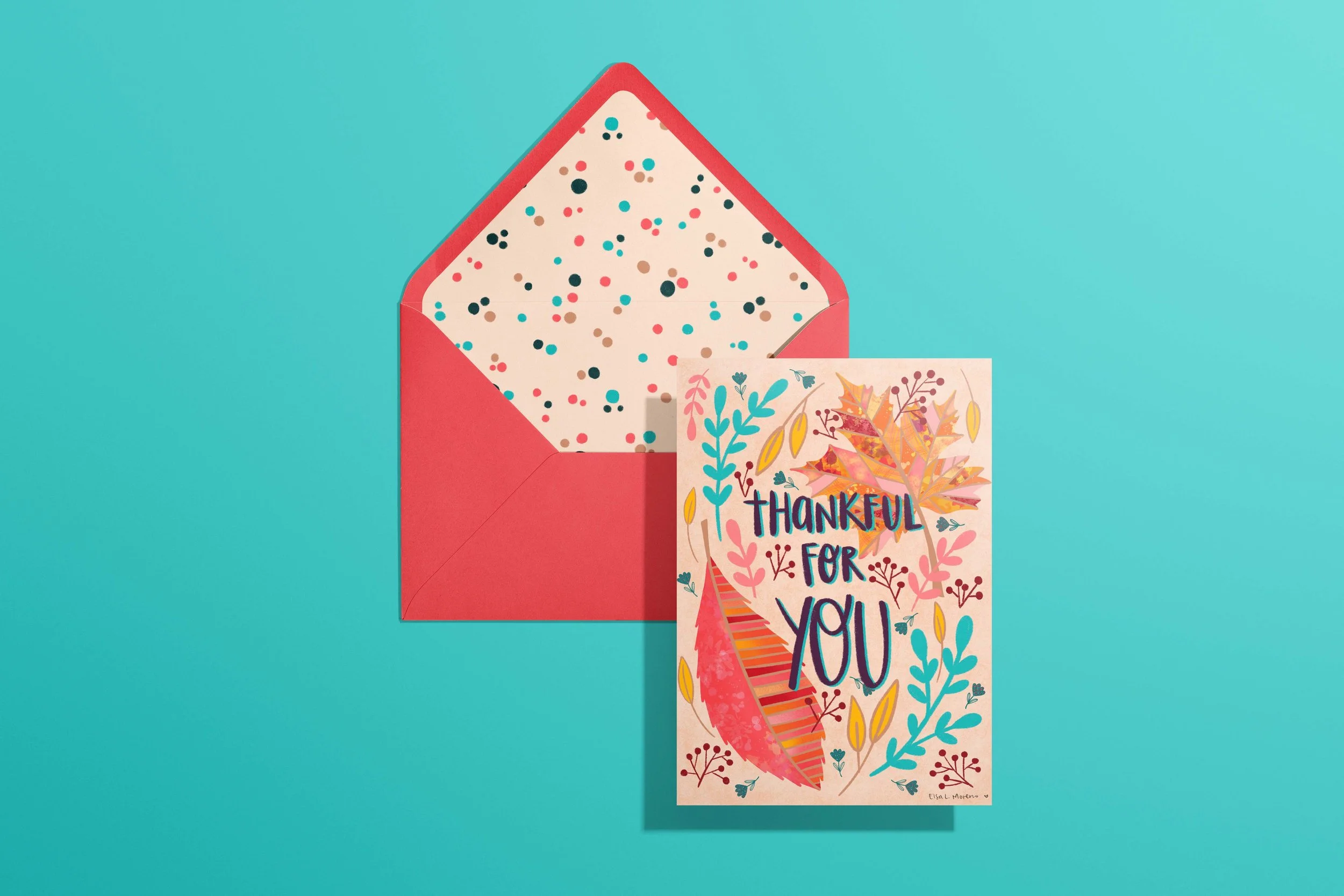 A card and envelope featuring leaves, branches and flowers in autumnal colors and the hand lettered message "Thankful for You". The envelope features a coordinating dotted pattern inside.