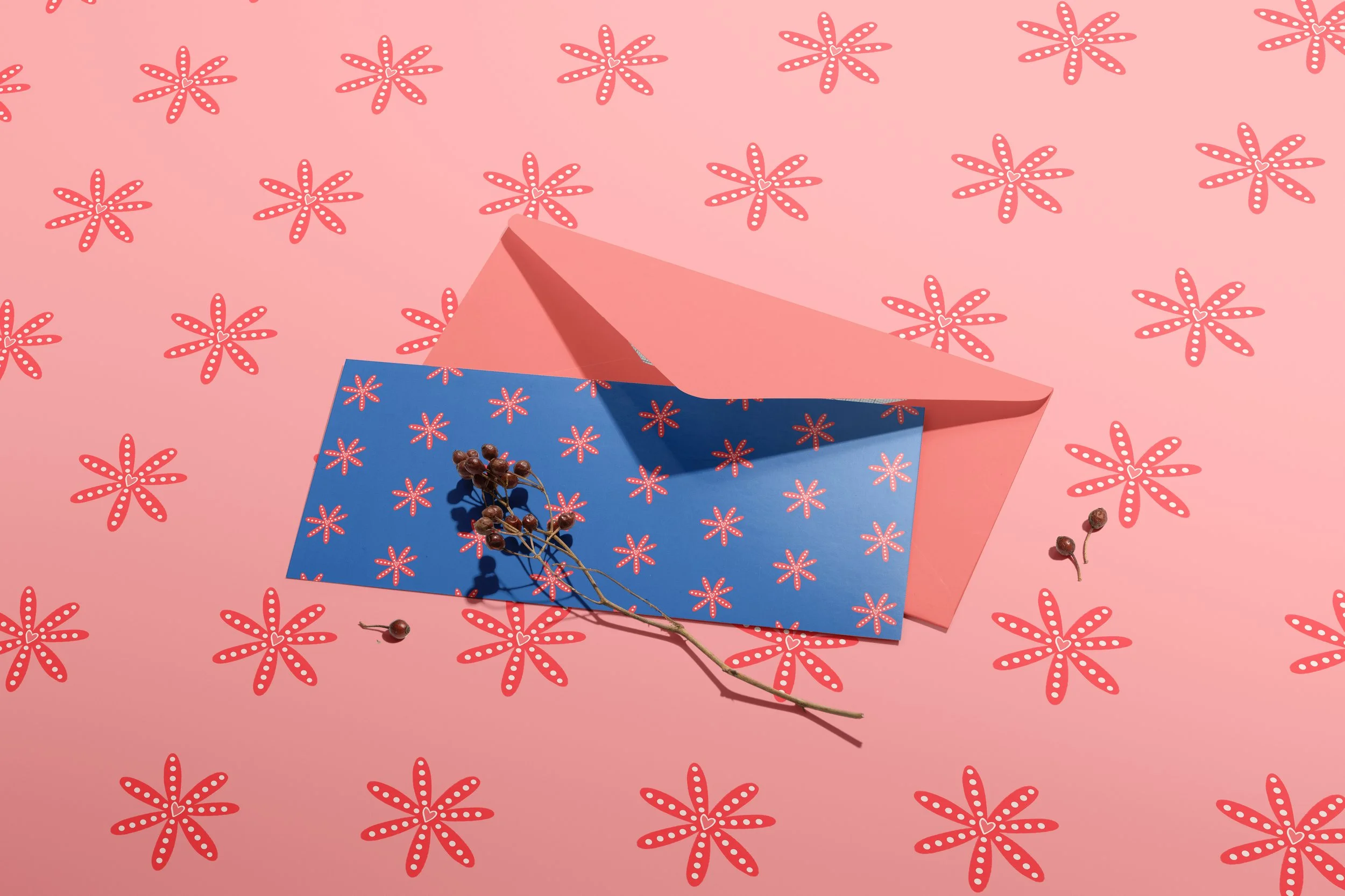 Card and envelope with a floral repeating pattern in blue on a floral repeating pattern in pink