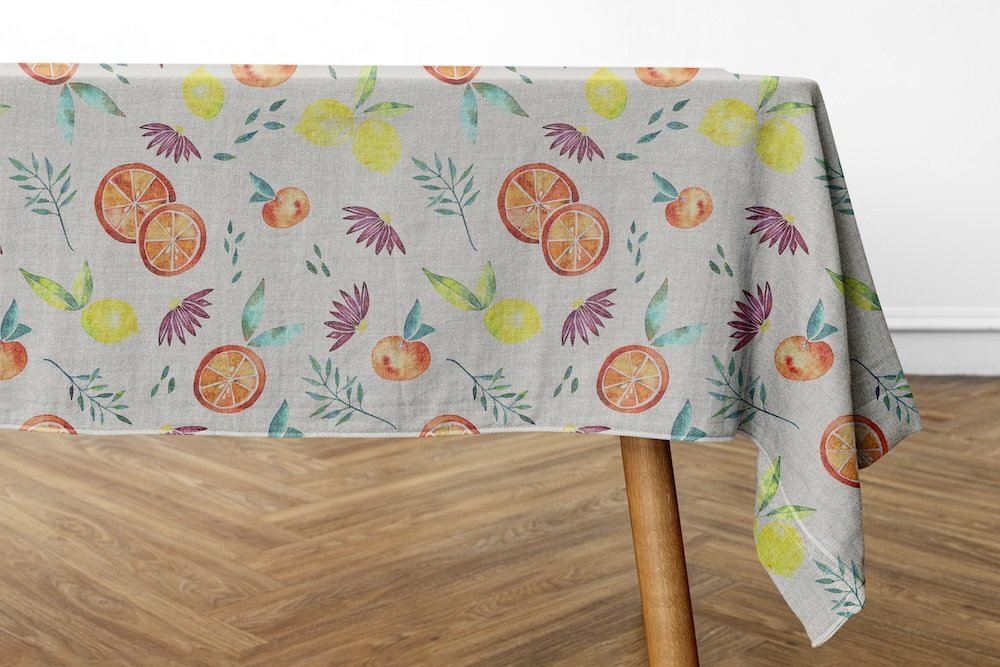 Tablecloth with a citrus repeating pattern draped over a wooden table