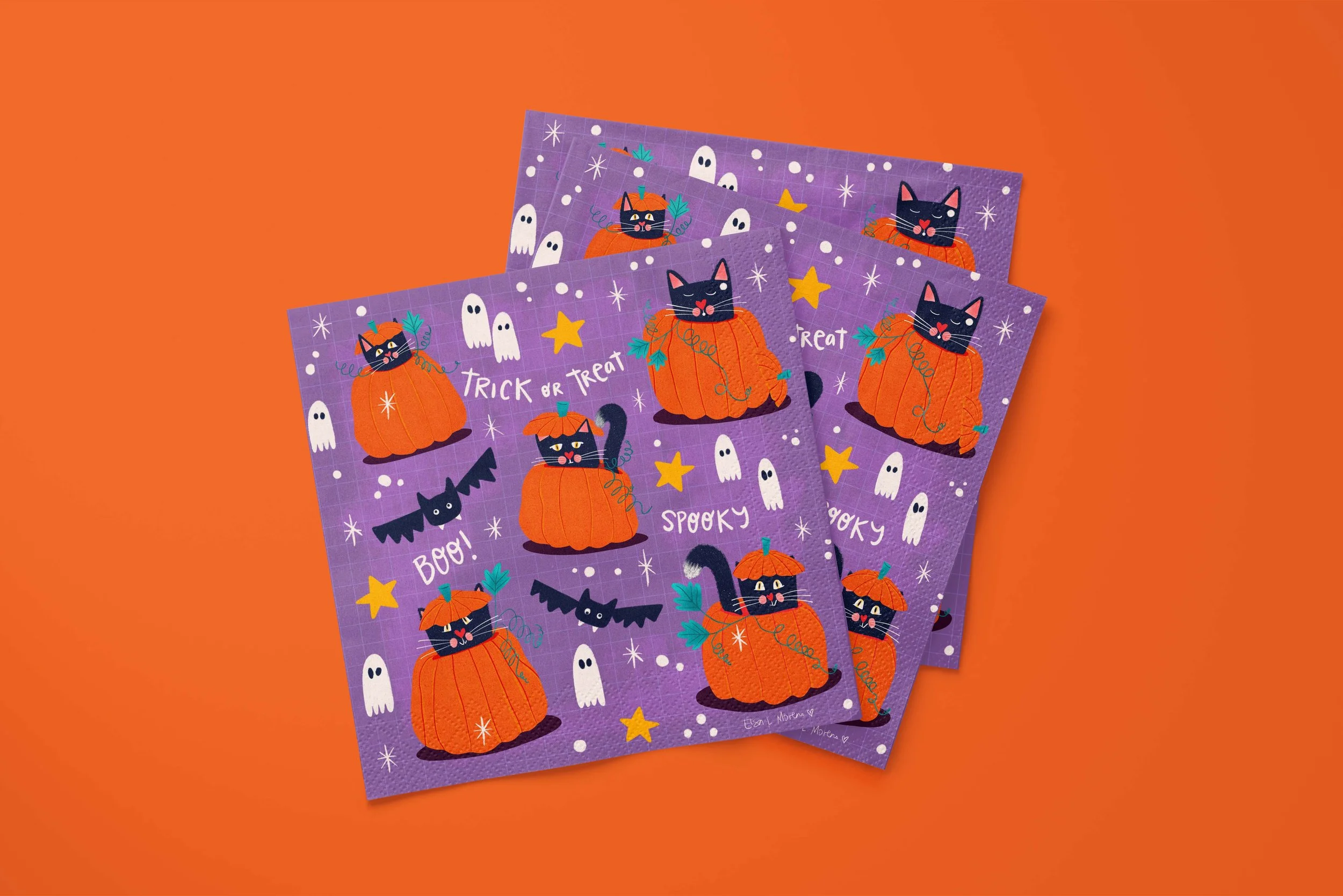 Three Halloween napkins with an illustration of five stylized black cats inside carved pumpkins, surrounded by yellow and white stars, ghosts and bats, all over a purple background with a subtle white grid texture. The words Spooky, Boo! and Trick or