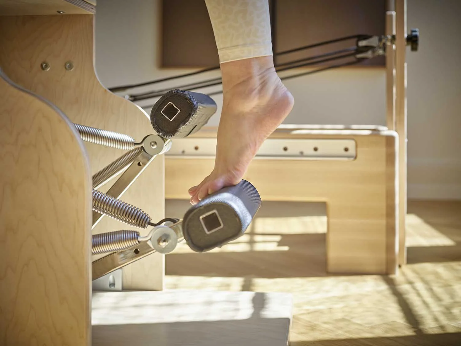 Hand, die Hantelstangen an einem Holztisch hebt.