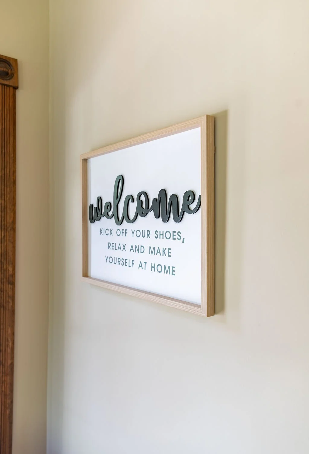 Decorative wall sign with the word "welcome" and a message about relaxing at home.