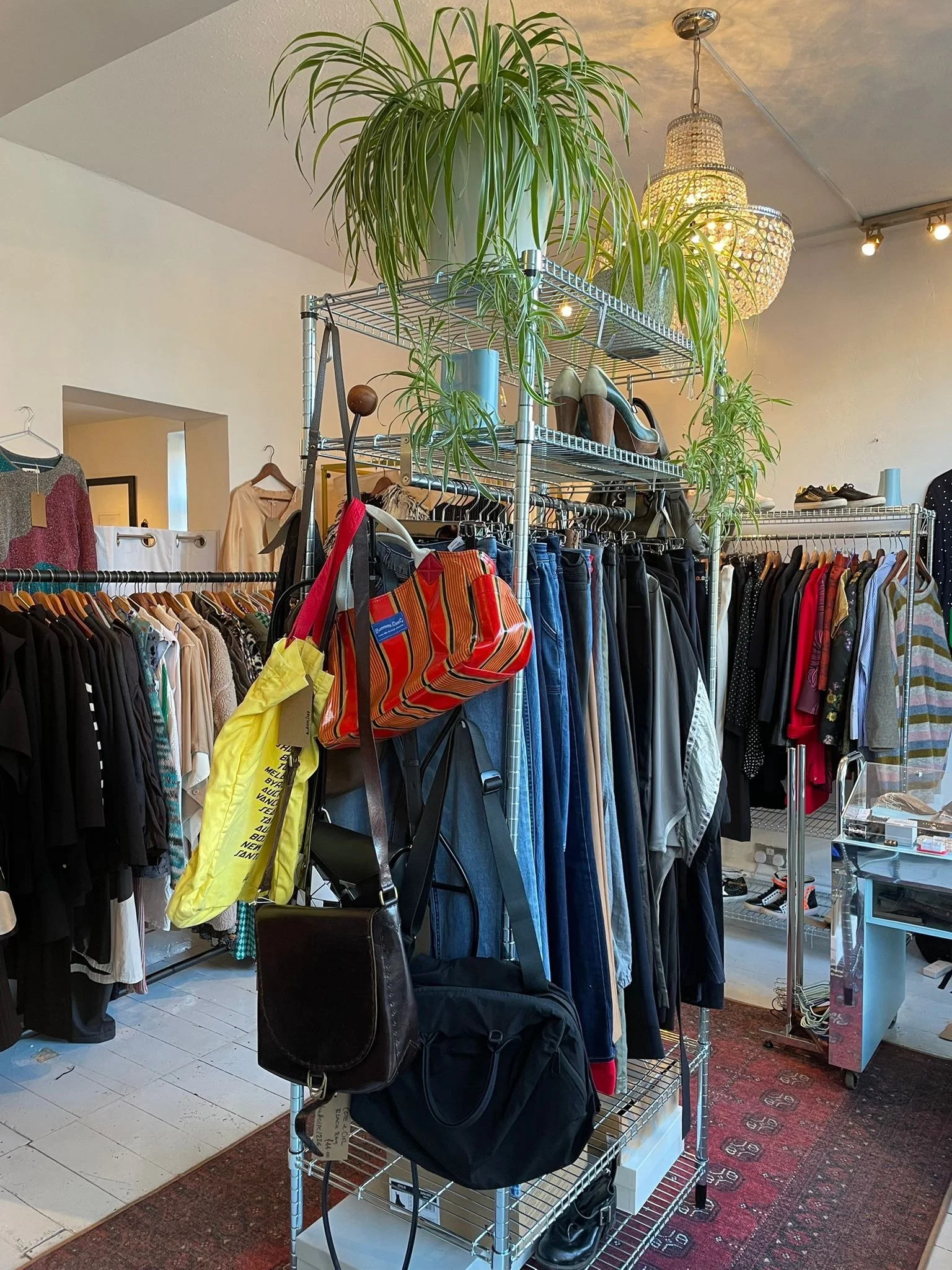 pre loved clothes and bags on a clothes rail in a shop
