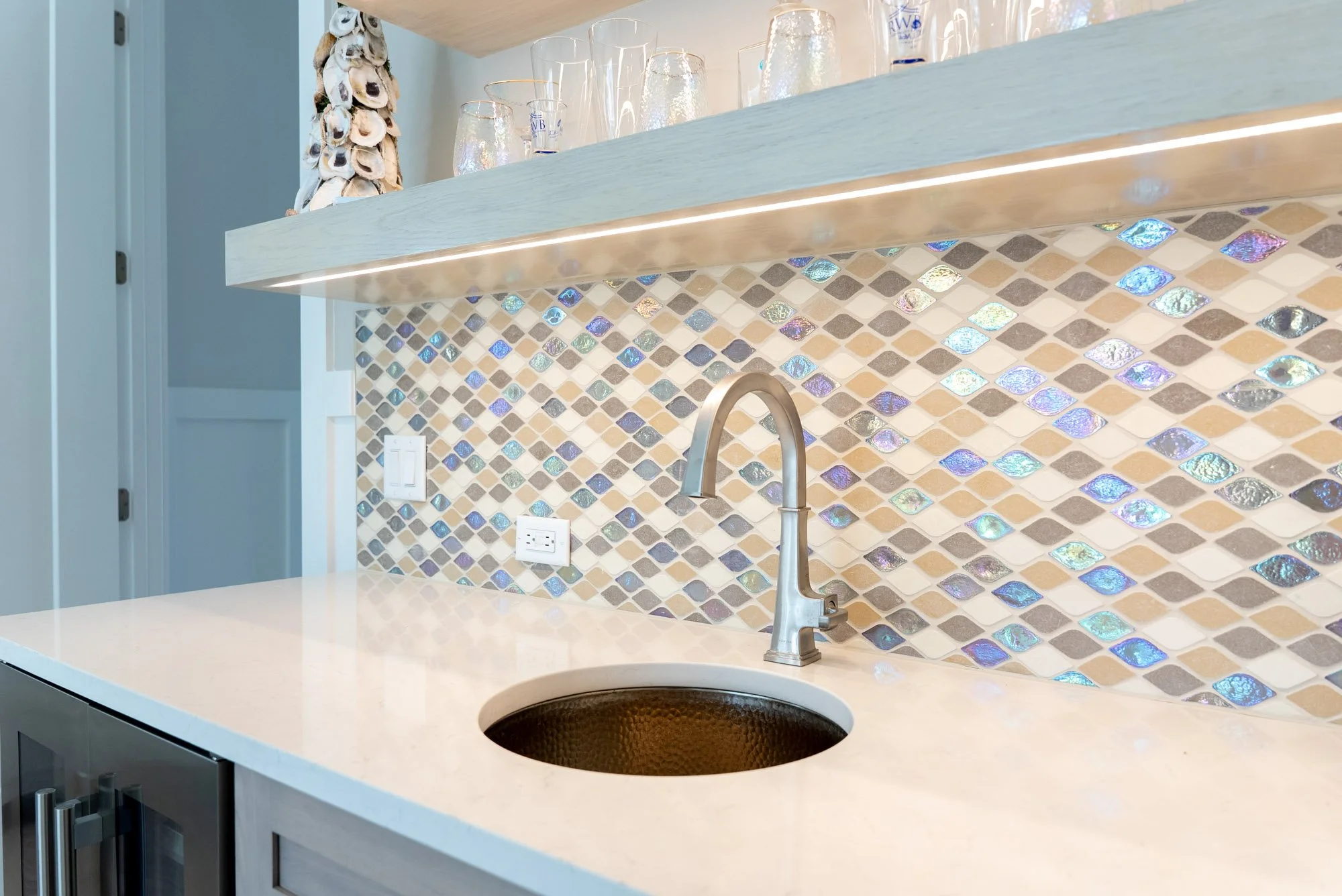 copper sink in front of a vibrant pear colored backsplash