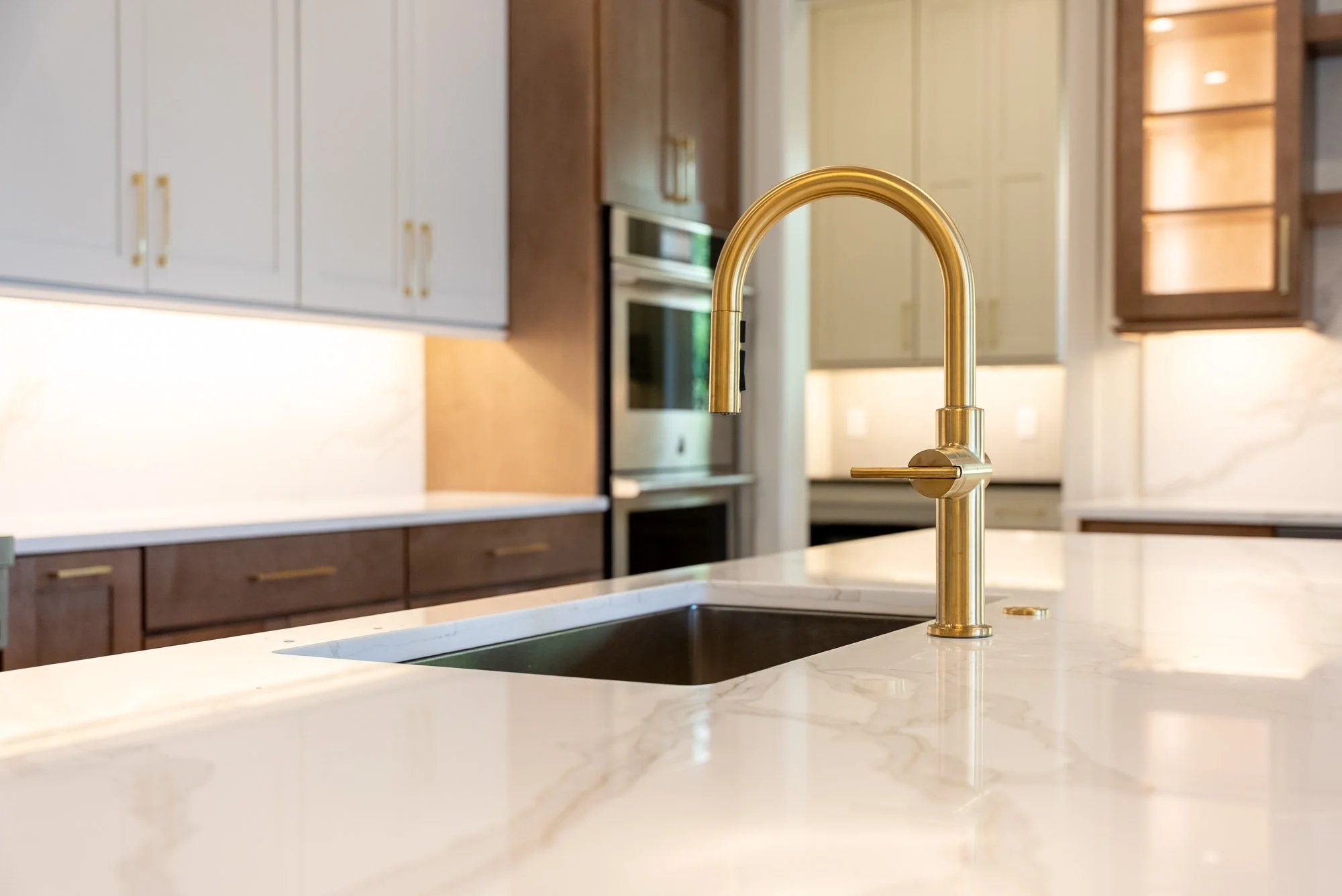 sink with gold hardware on a kitchen island