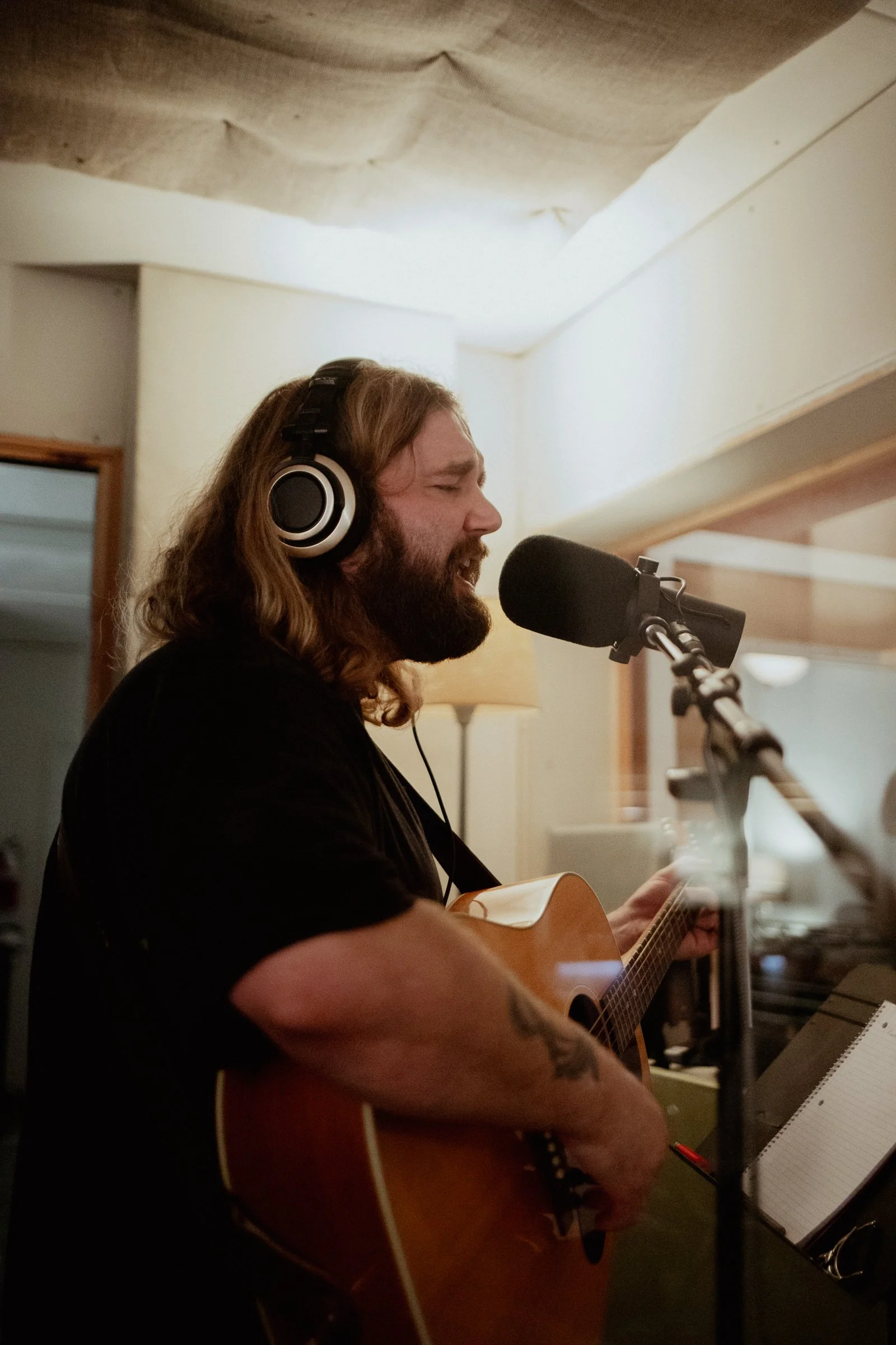 Artist in sound booth record vocals