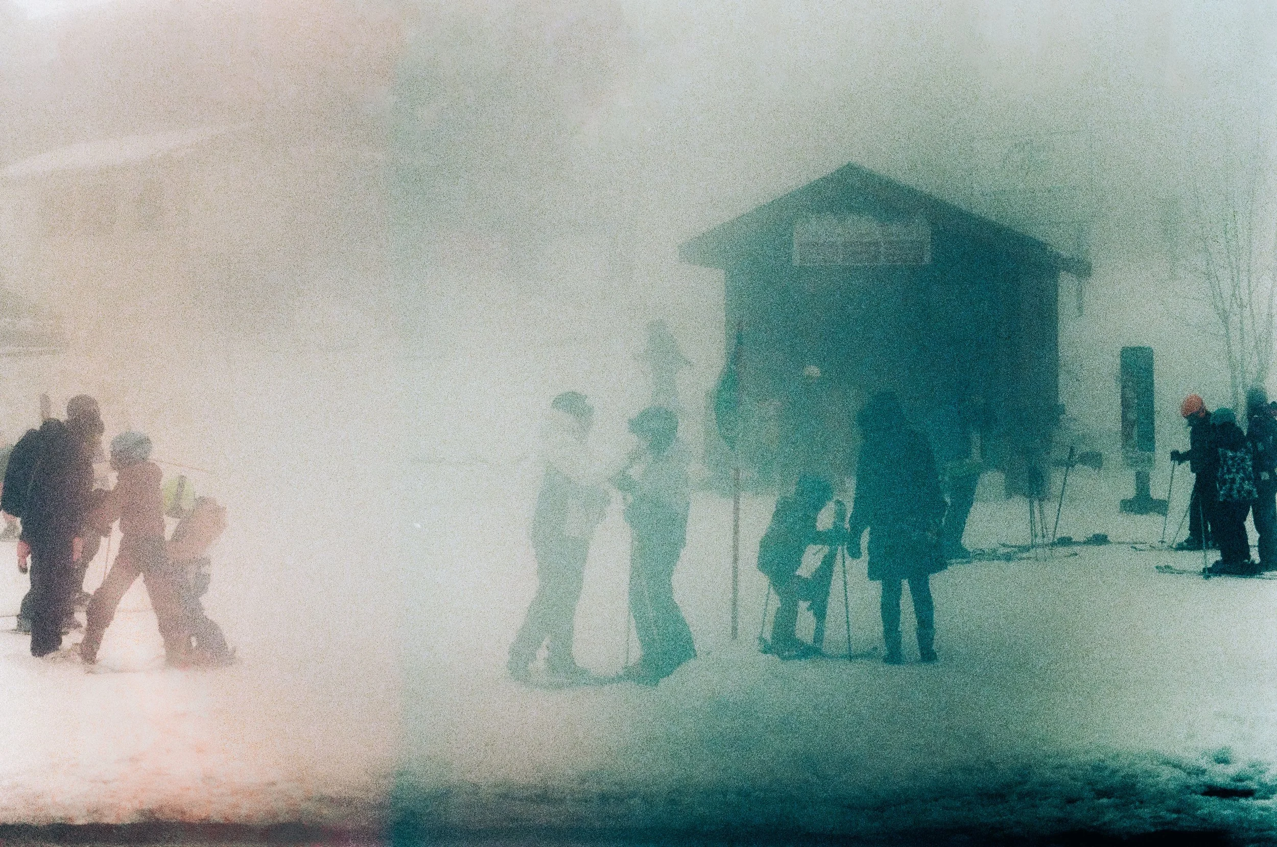 A group of people in winter clothing walking and standing in a snowy, foggy environment near a building, with some taking photos and others engaged in conversation.