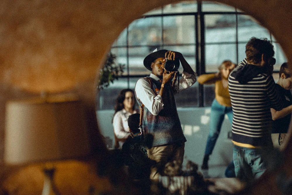 A photographer reflected in a round mirror during an event