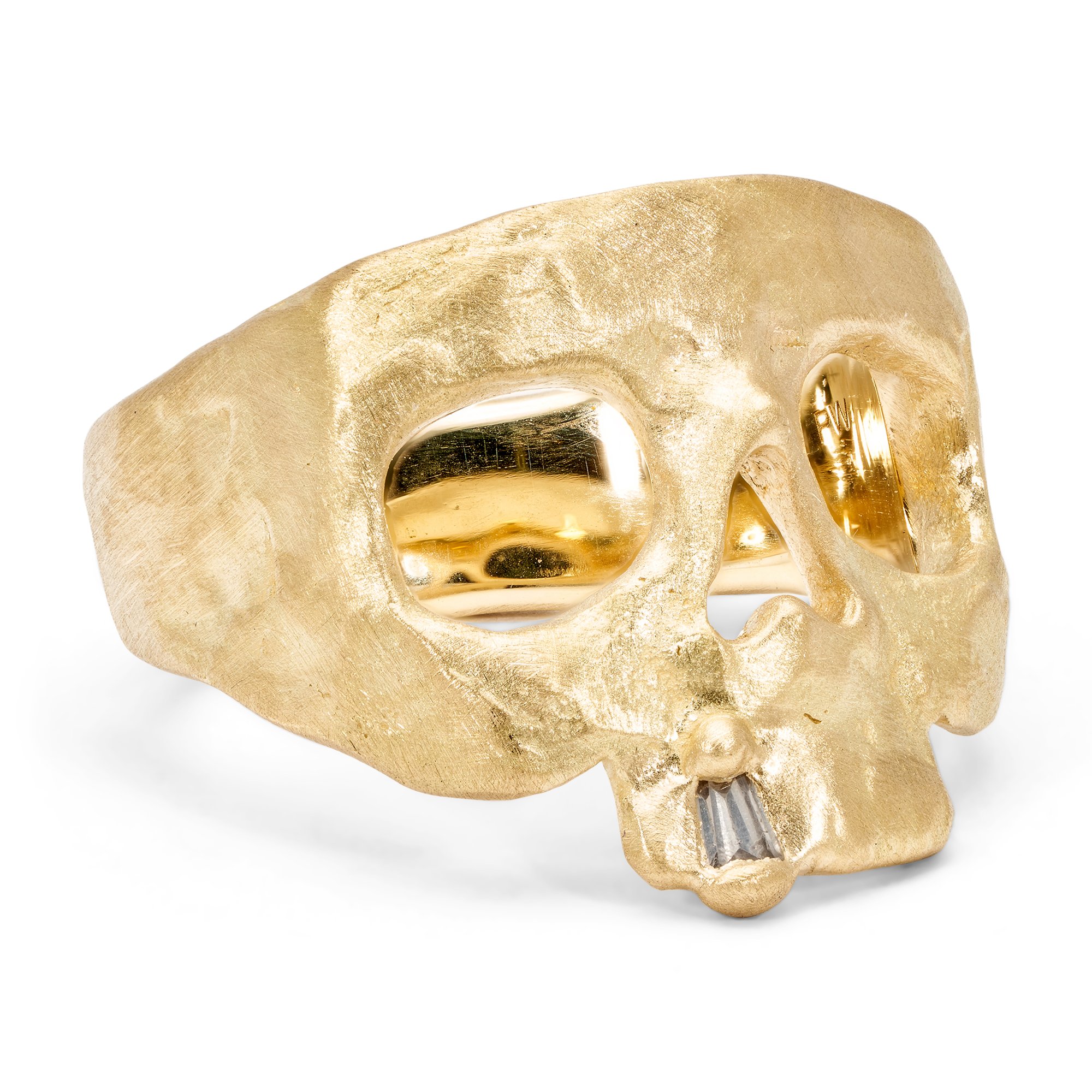 Gold skull-shaped ring with hollow eye sockets and a striped mouth design.
