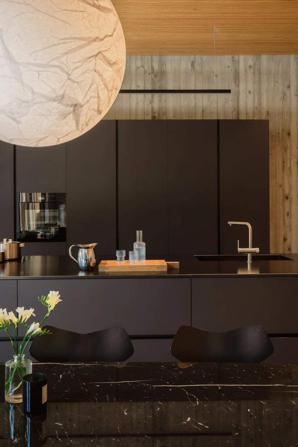 Modern black kitchen with 103 model chairs from Arne Jacobsen