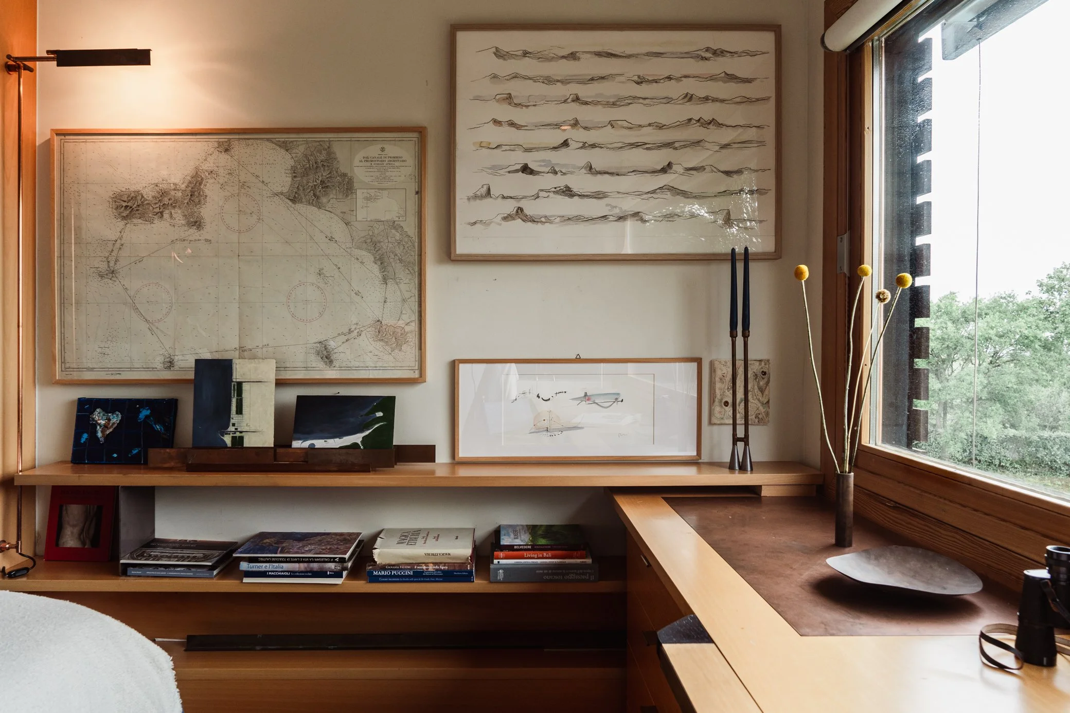Midcentury modern styled office space with maps and drawings on the walls
