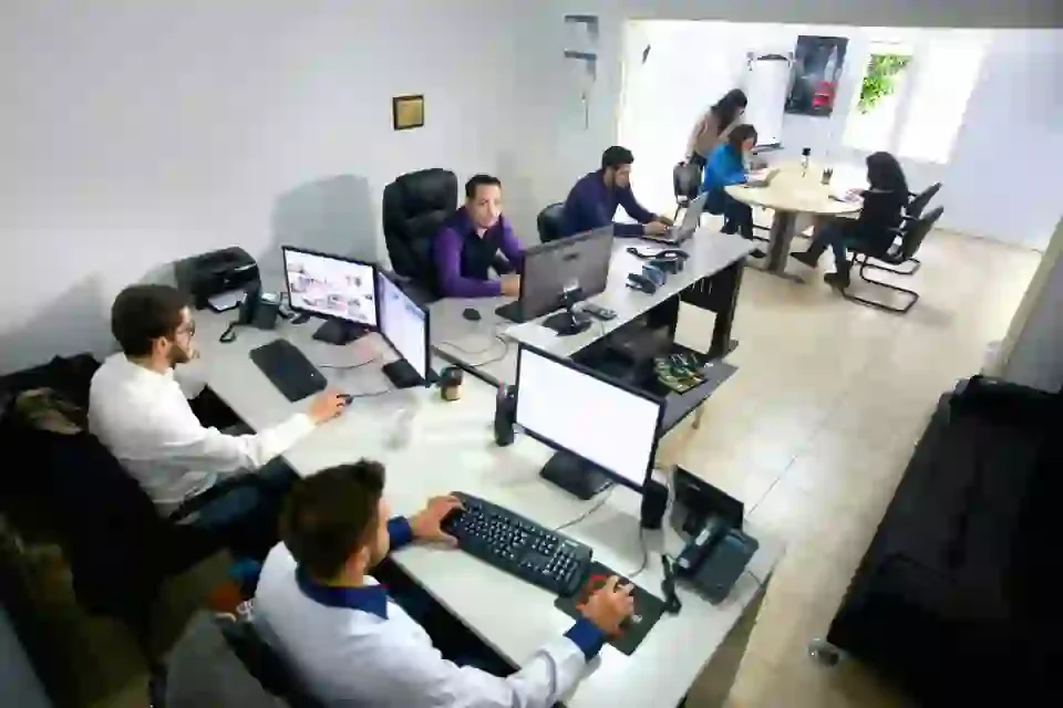 Bureau avec plusieurs employés travaillant sur des ordinateurs en open space.