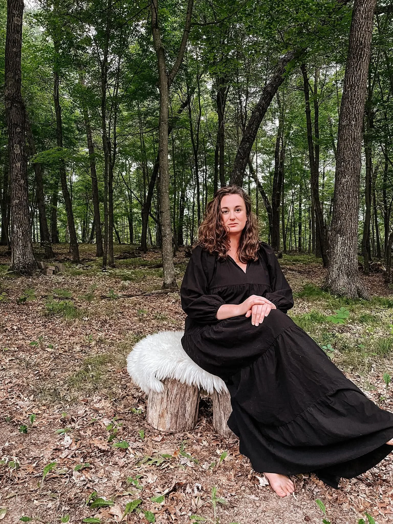 Jen Anderson sitting on a bench in the forest.
