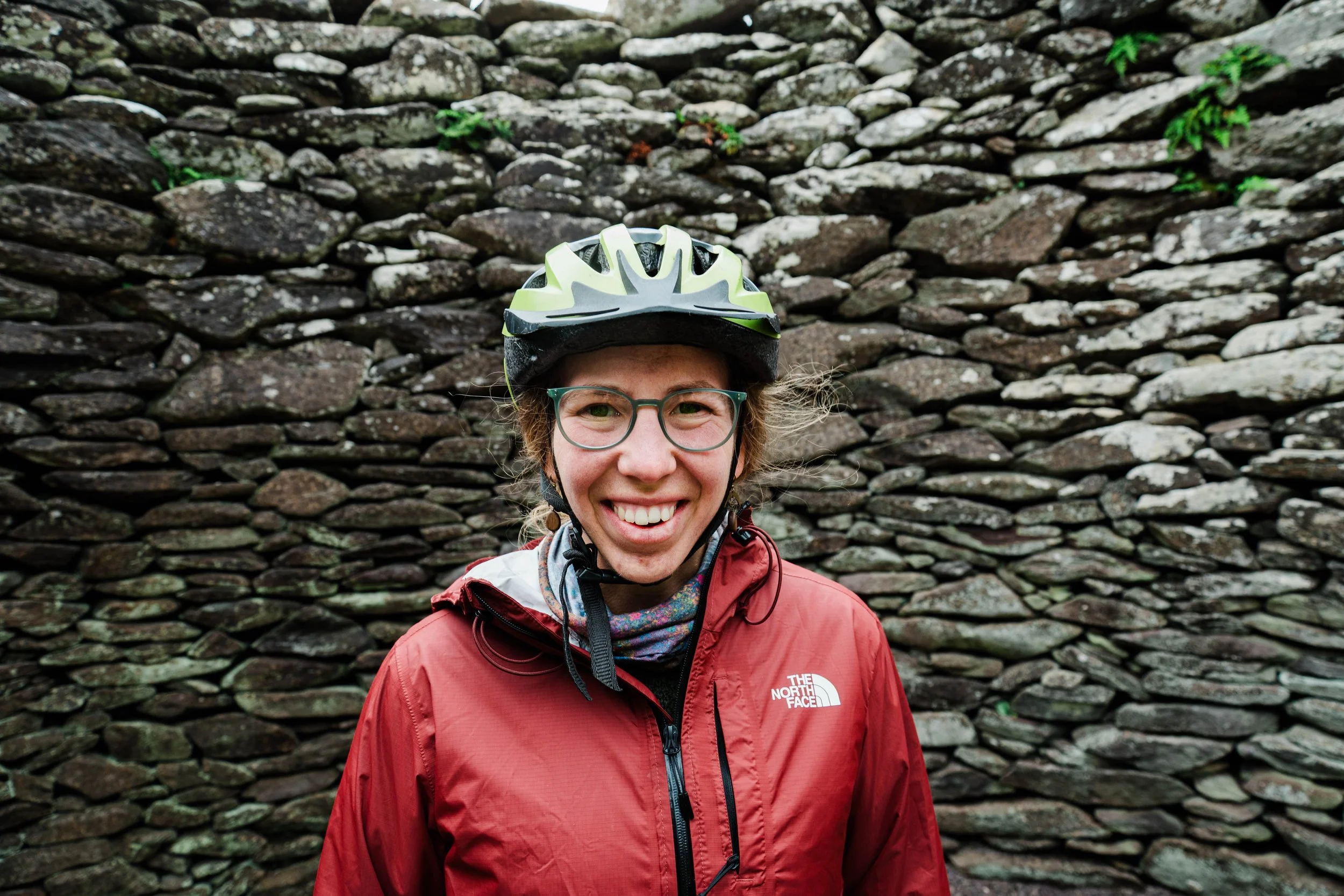 Jackie wearing bike gear in front of stone wall
