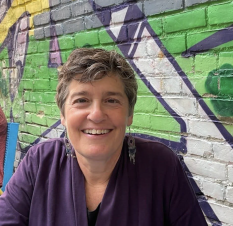 Jane sitting in front of a graffiti wall