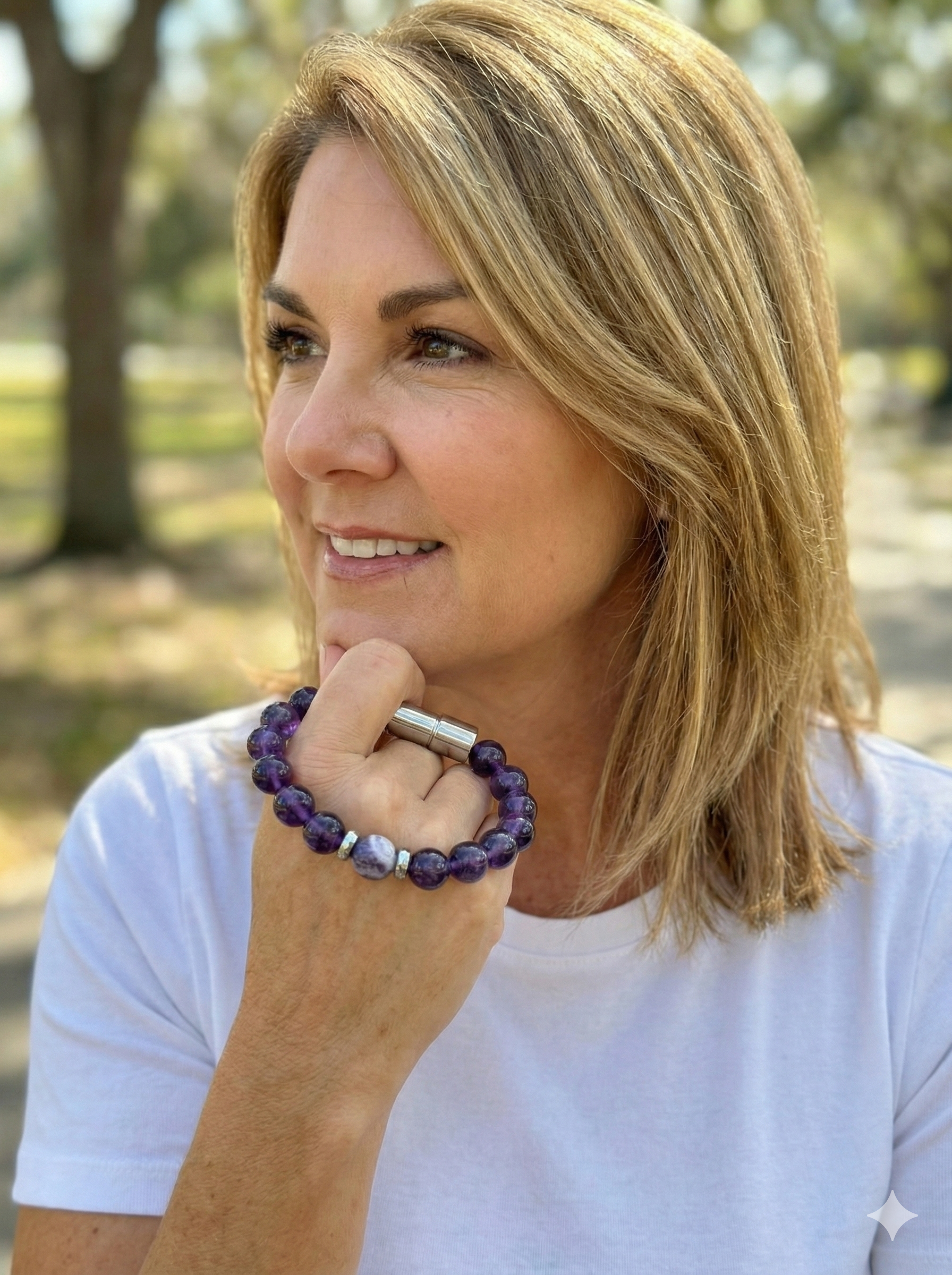 Diane Friedman Founder of Enusia pill holder bracelet in the park about to slide the bracelet on