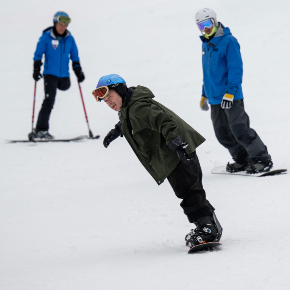 Adaptive snowboarder riding downhill