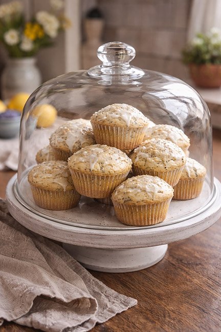 muffins piled under a glass cake dome